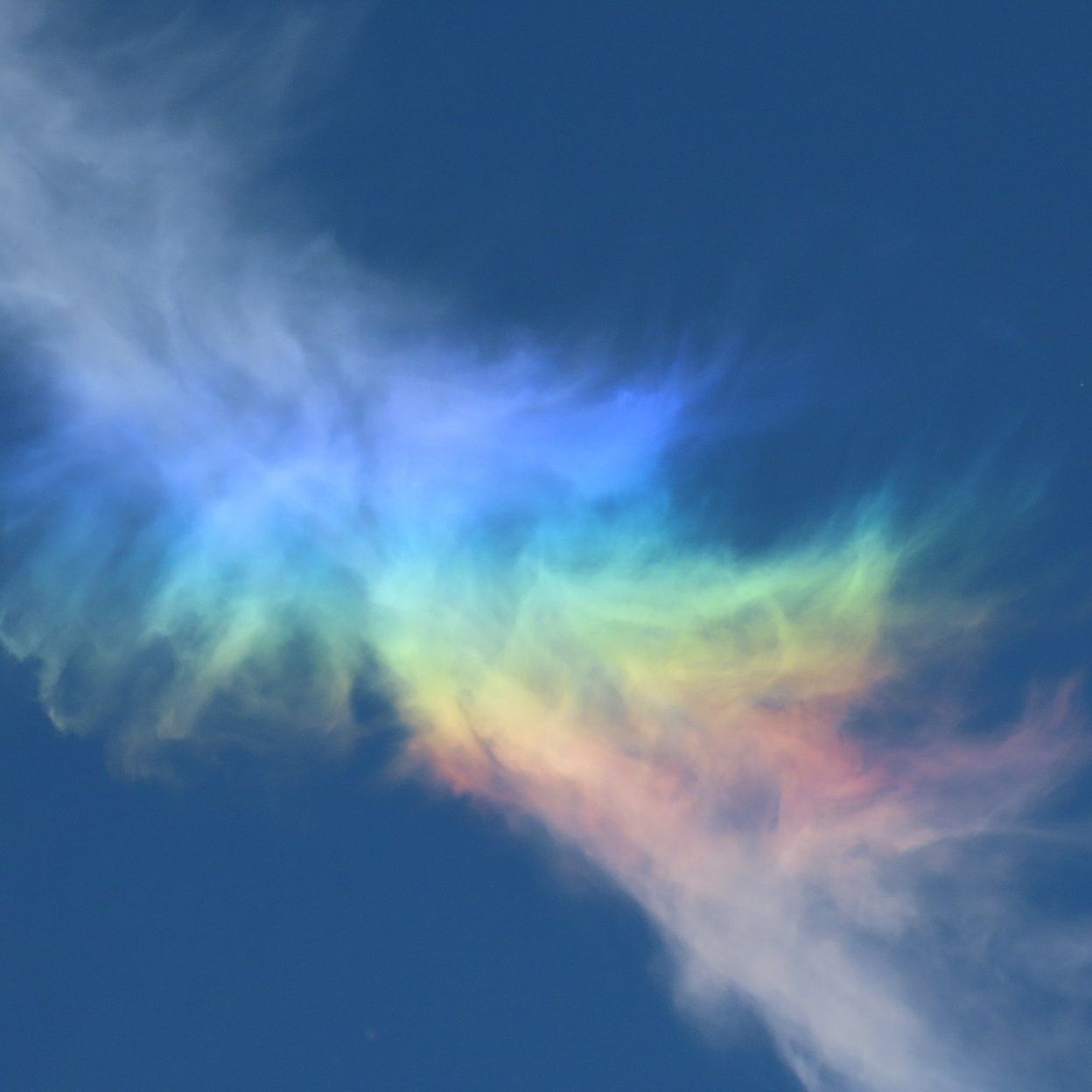 Un Arc-en-ciel Est Entouré De Nuages Et Le Ciel Est Bleu Et Le Soleil  Brille.