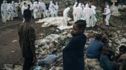 De jeunes habitants regardent des membres de la Croix-Rouge congolaise et de la Protection civile enterrer des dizaines de corps, le 3 février 2025 dans un cimetière de Goma en RDC.