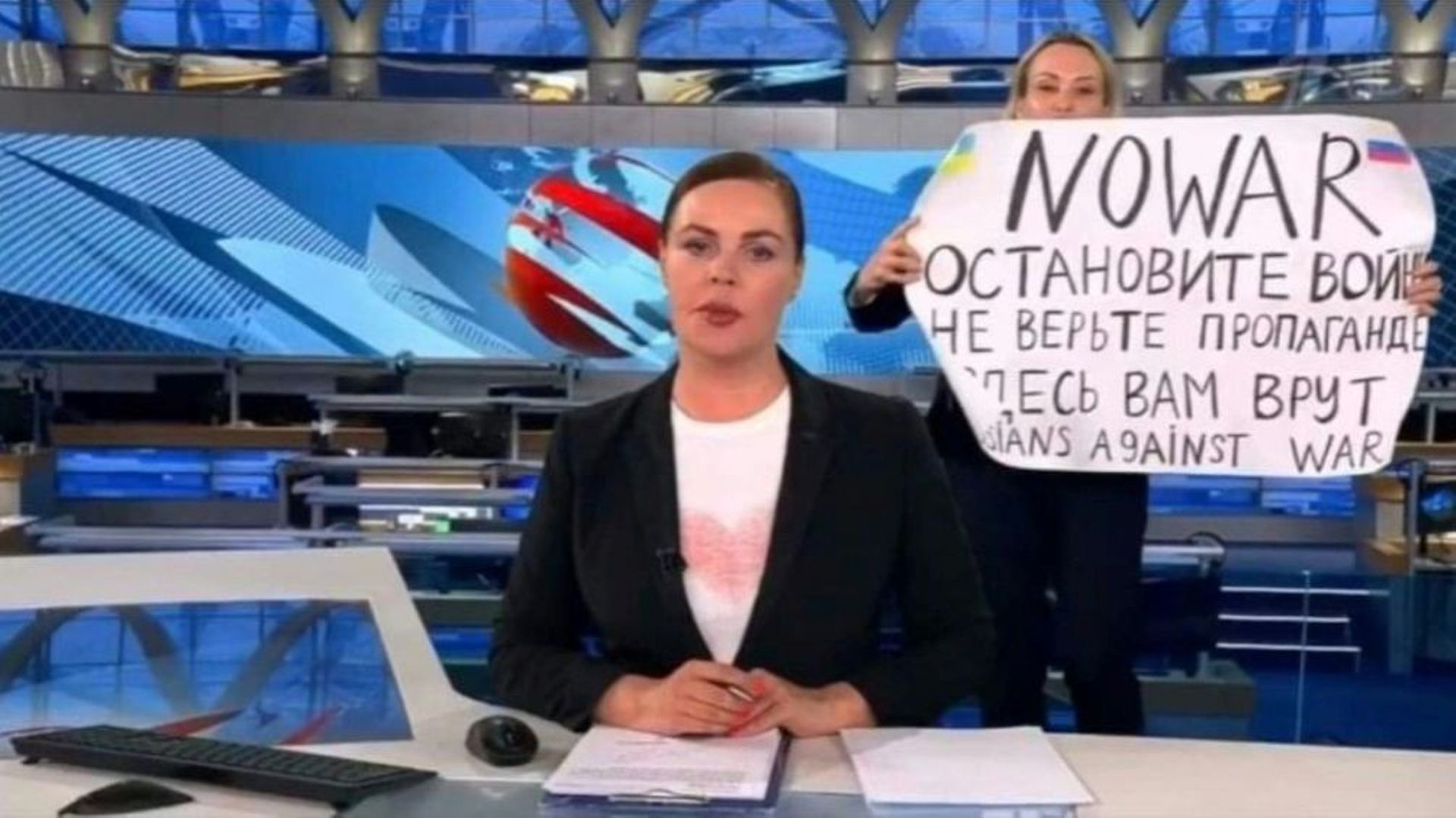 Une capture vidéo du 15 mars 2022 montre Marina Ovsyannikova tenant une pancarte "Non à la guerre. Ne croyez pas la propagande. On vous ment, ici", juste derrière la présentatrice de la chaîne russe Channel One