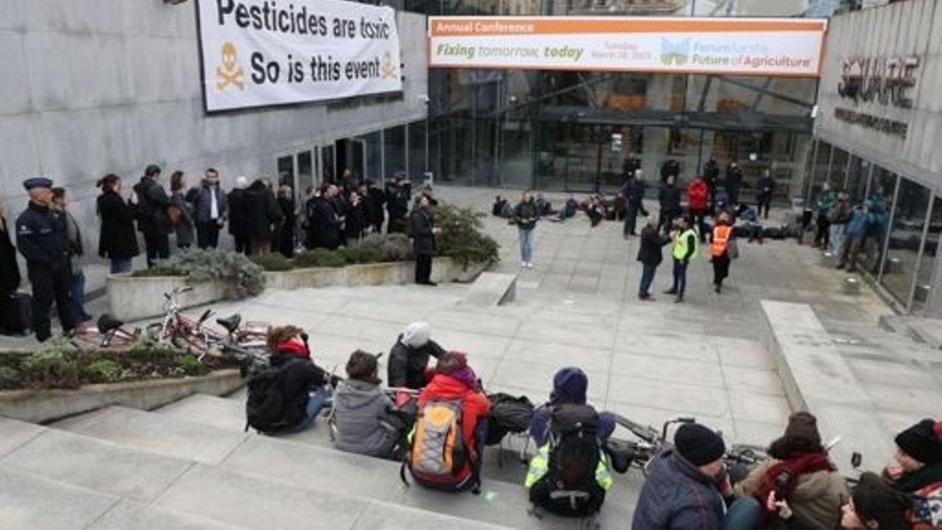 Des manifestants se sont couchés devant l'entrée de la Place lors d'une action de protestation du collectif "Pas d'avenir pour l'agro-industrie" dans le cadre du Forum pour l'Avenir de l'Agriculture (FFA), à Bruxelles, le mardi 28 mars 2023. 