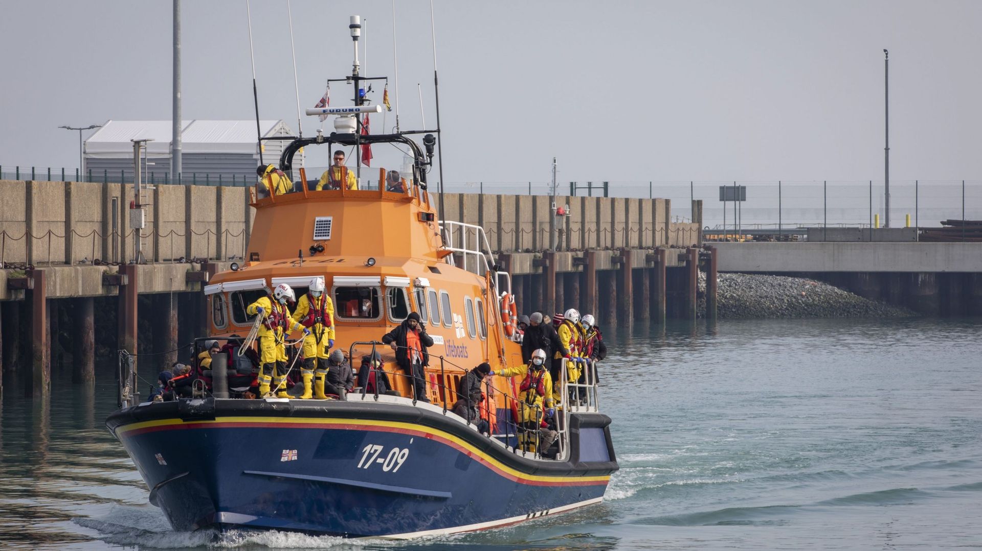 Des demandeurs d'asile arrivant sur les quais de Douvres à bord du bateau de la RNLI de Douvres après avoir été secourus dans la Manche lors de la traversée le 3 mars 2022 à Douvres, Kent, Royaume-Uni. 

