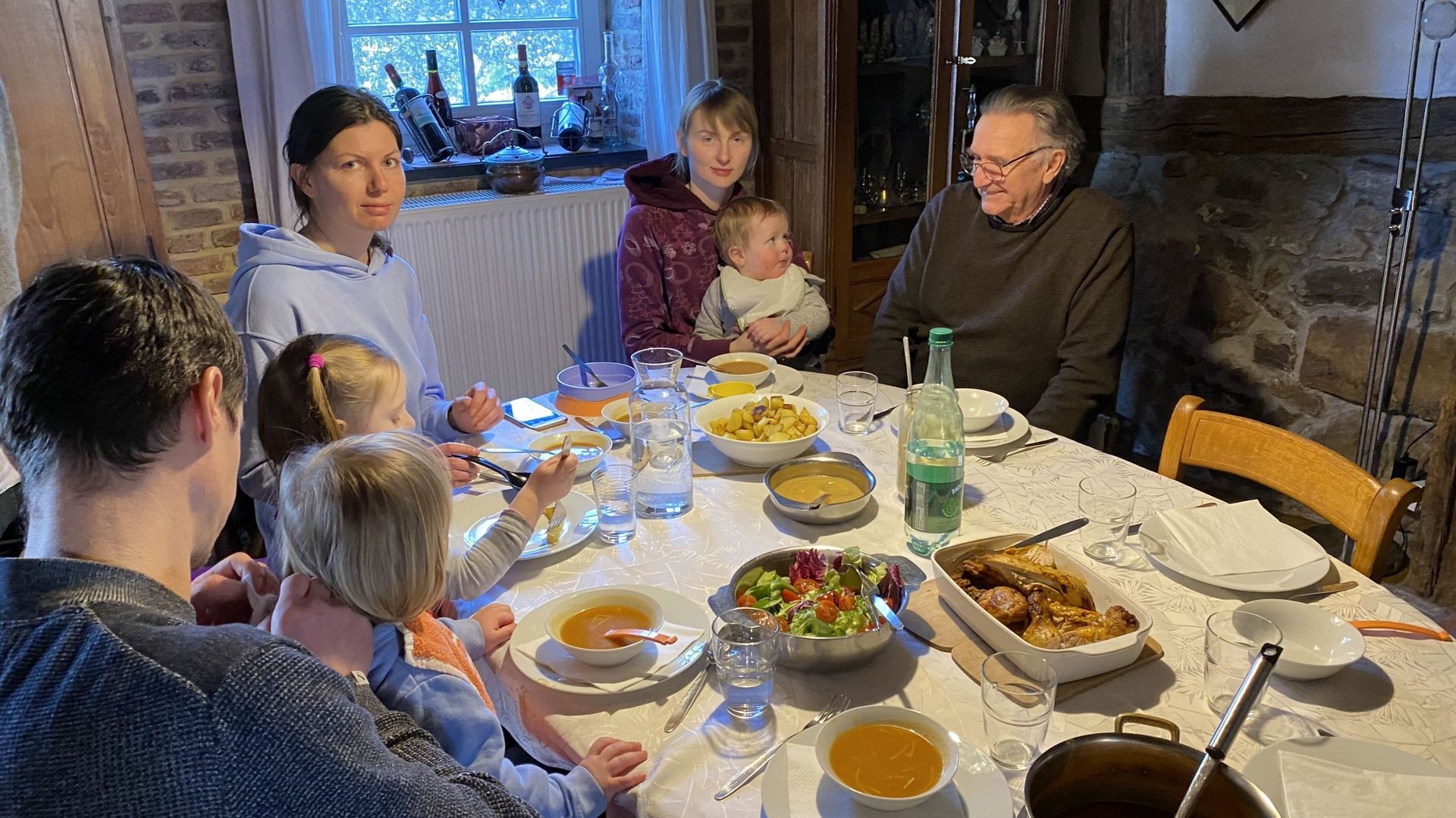 Etienne, un habitant de Beauraing  échange quelques mots lors d'un repas avec la famille ukrainienne qu'il accueille pour l'instant.  