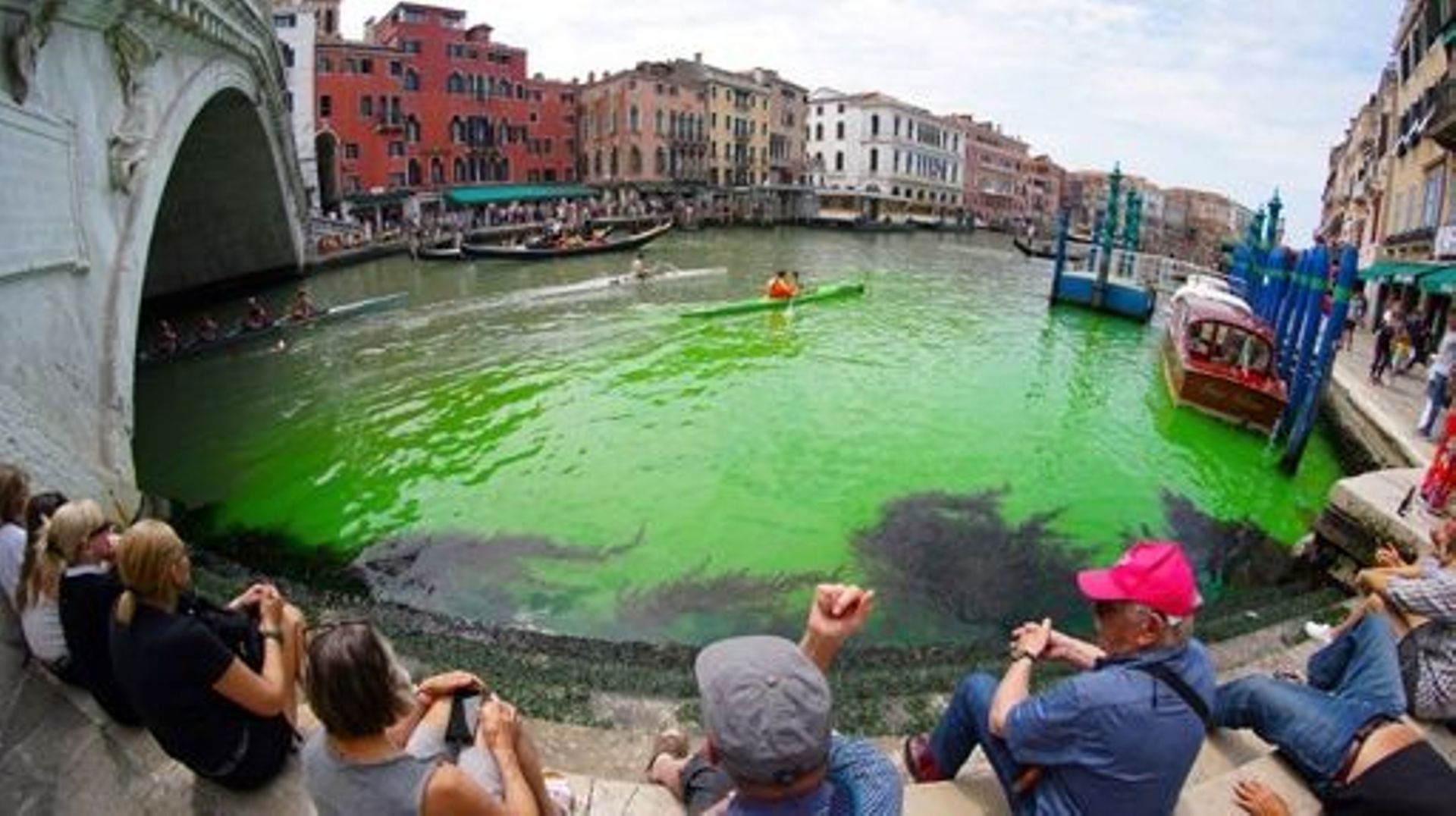 A photo taken and made available on May 28, 2023 by Italian news agency Ansa, shows fluorescent green waters below the Rialto Bridge in Venice's Grand Canal. The prefect called an urgent meeting on May 28 with the police to investigate the origin of the l