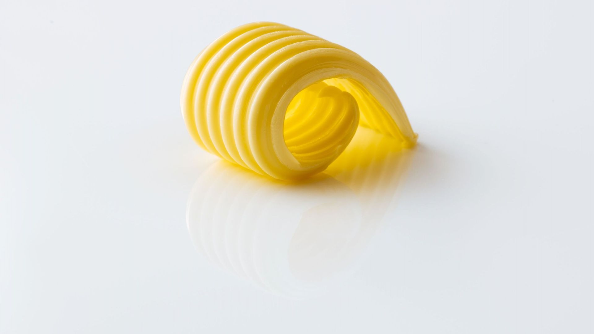 Curl of butter on white ground