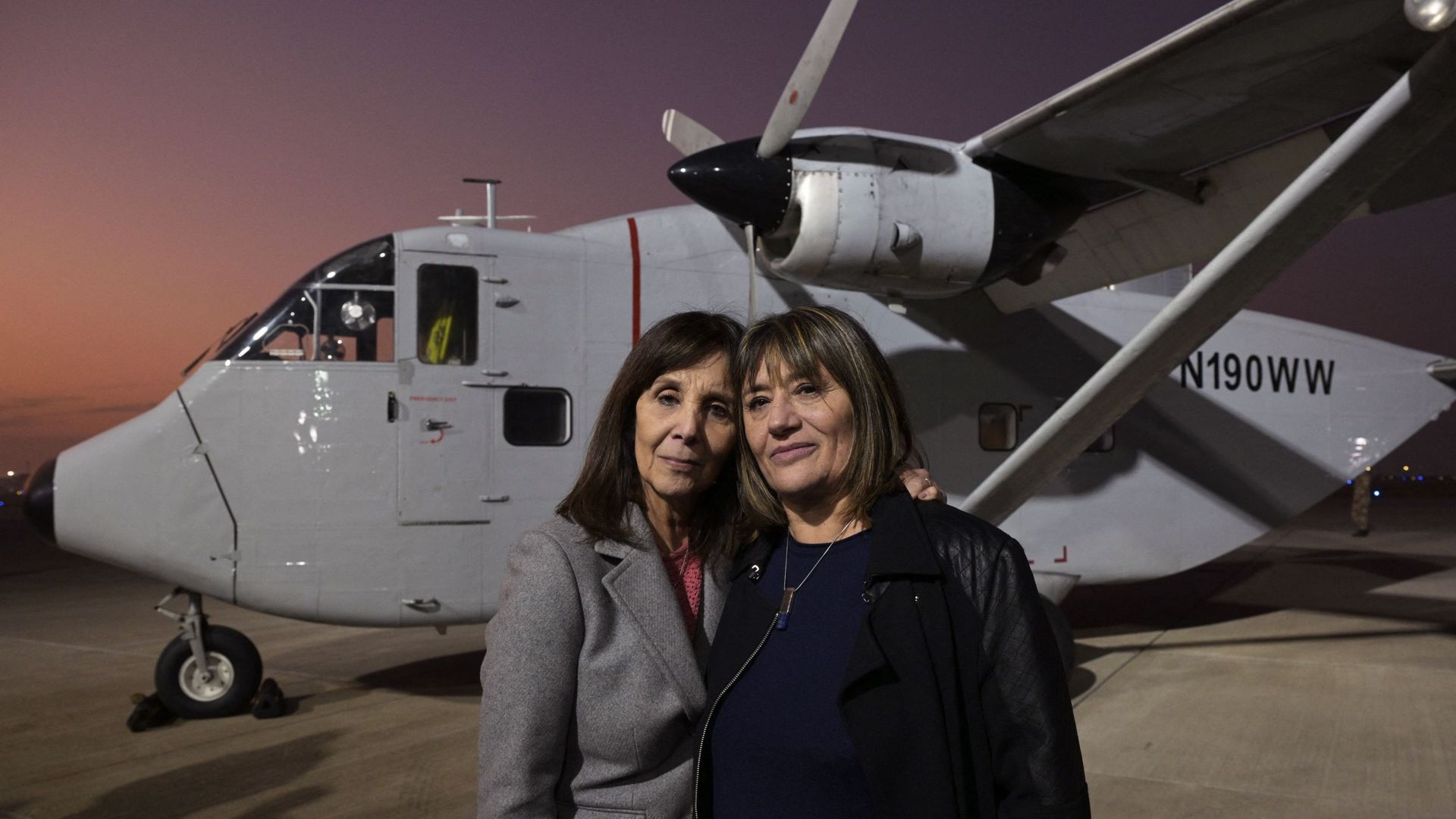 Cecilia De Vicenti (à droite) et Mabel Careaga (à gauche) posent, le 26 juin 2023, devant l’avion d’où leurs mères, Azucena Villaflor et Esther Ballestrino de Careaga, fondatrices du mouvement des Mères de la Plaza de Mayo, ont été jetées à la mer.