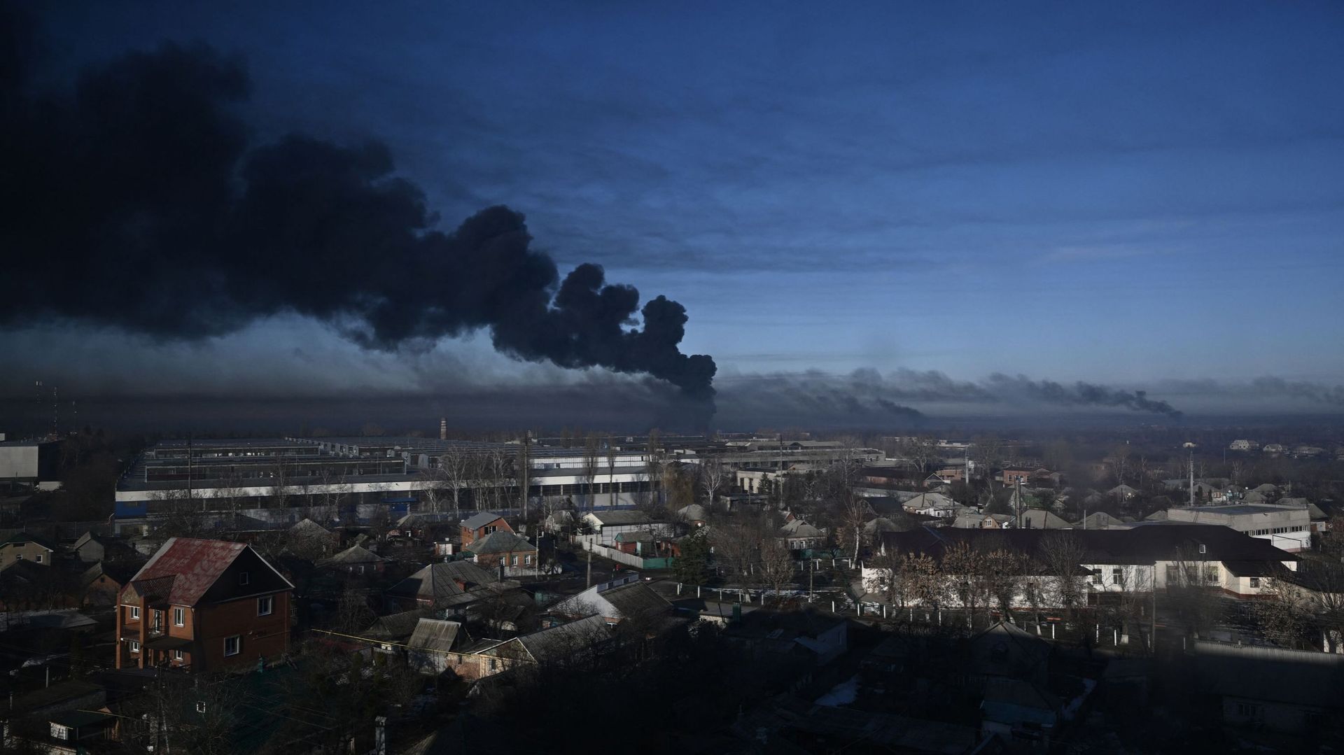 De la fumée noire s'élève d'un aéroport militaire à Chuguyev, près de Kharkiv, le 24 février 2022. 