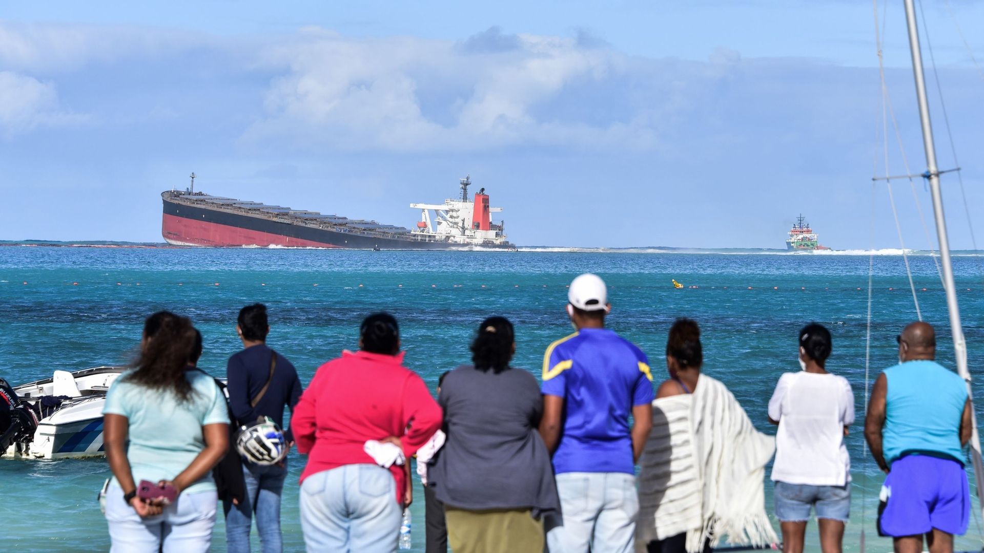 De la terre ferme, habitants et touristes contemplent l'angoissant spectacle : du navire échoué s'échappent des hydrocarbures. Les plages environnantes sont interdites.