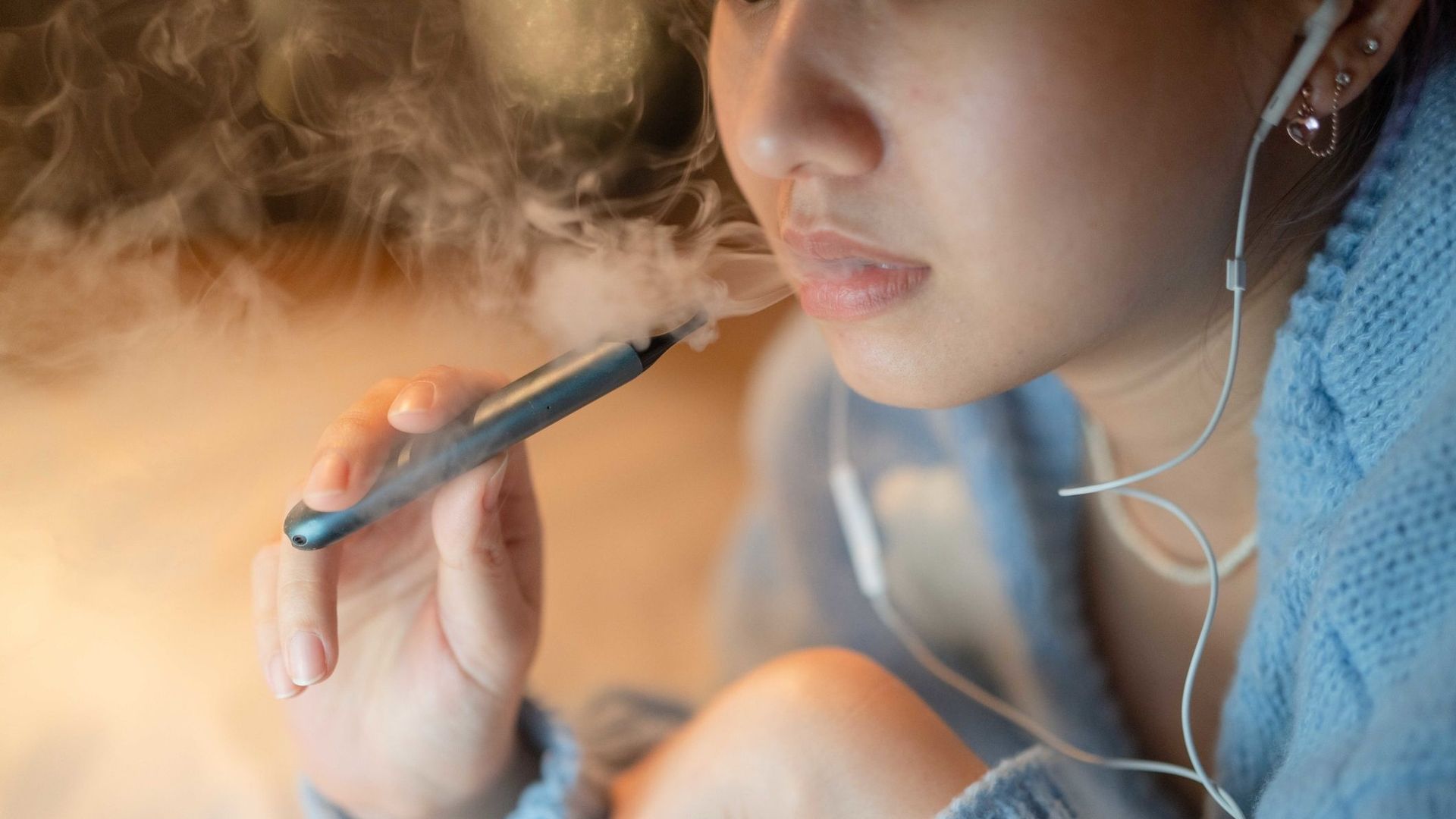 Jeune femme fumant une cigarette électronique (illustration)