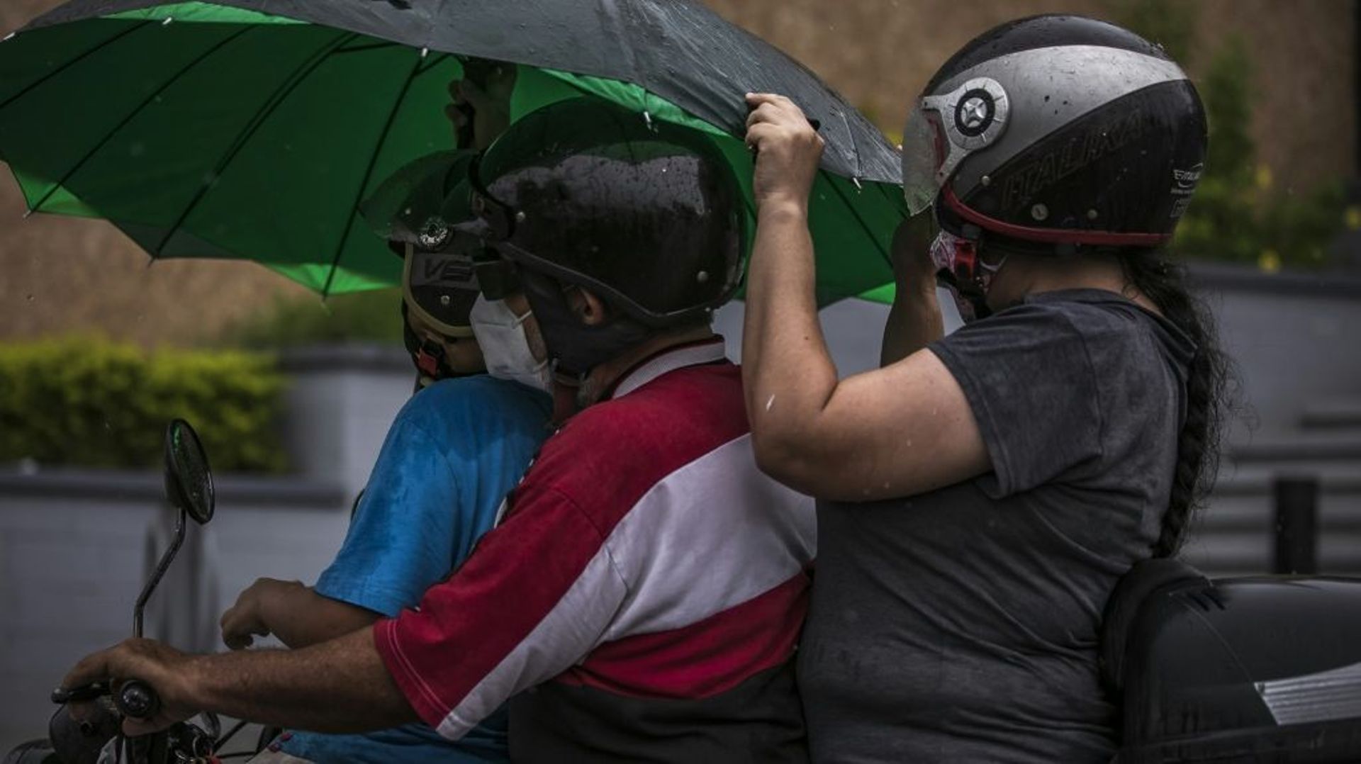 Des personnes à moto sous une pluie battante avant l'arrivée de la tempête Pamela, qui devrait se transformer en ouragan, le 12 octobre 2021 à Culiacan, au Mexique