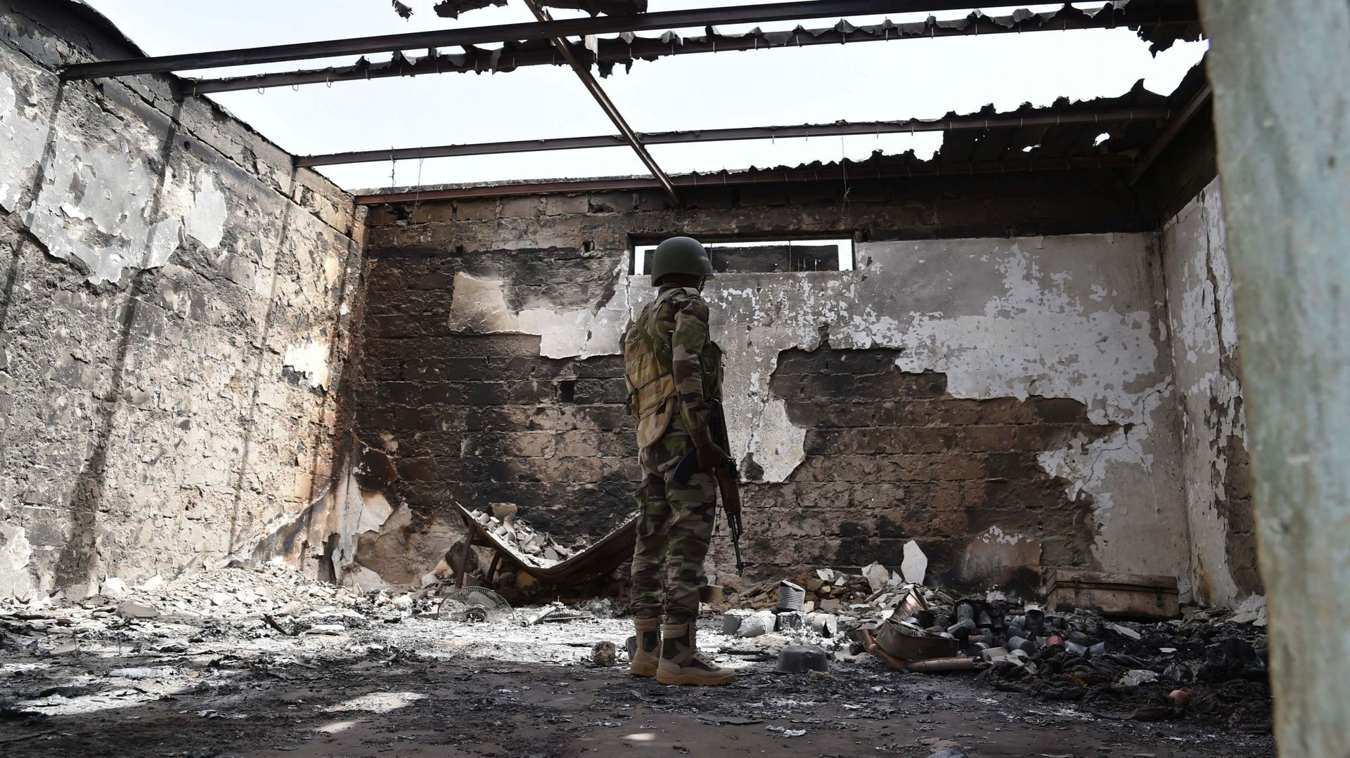 Un soldat nigérien dans les ruines d'une maison après l'attaque de Boko Haram à Bosso