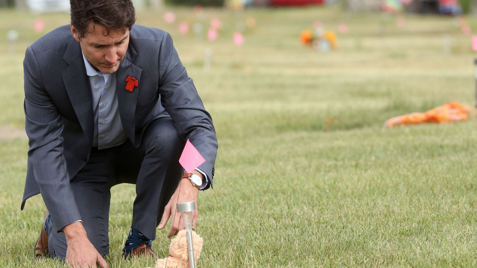 Le Premier ministre canadien Justin Trudeau place un ours en peluche sur une tombe anonyme de la Première nation de Cowessess, où 751 tombes anonymes ont été trouvées (6 juillet 2021)