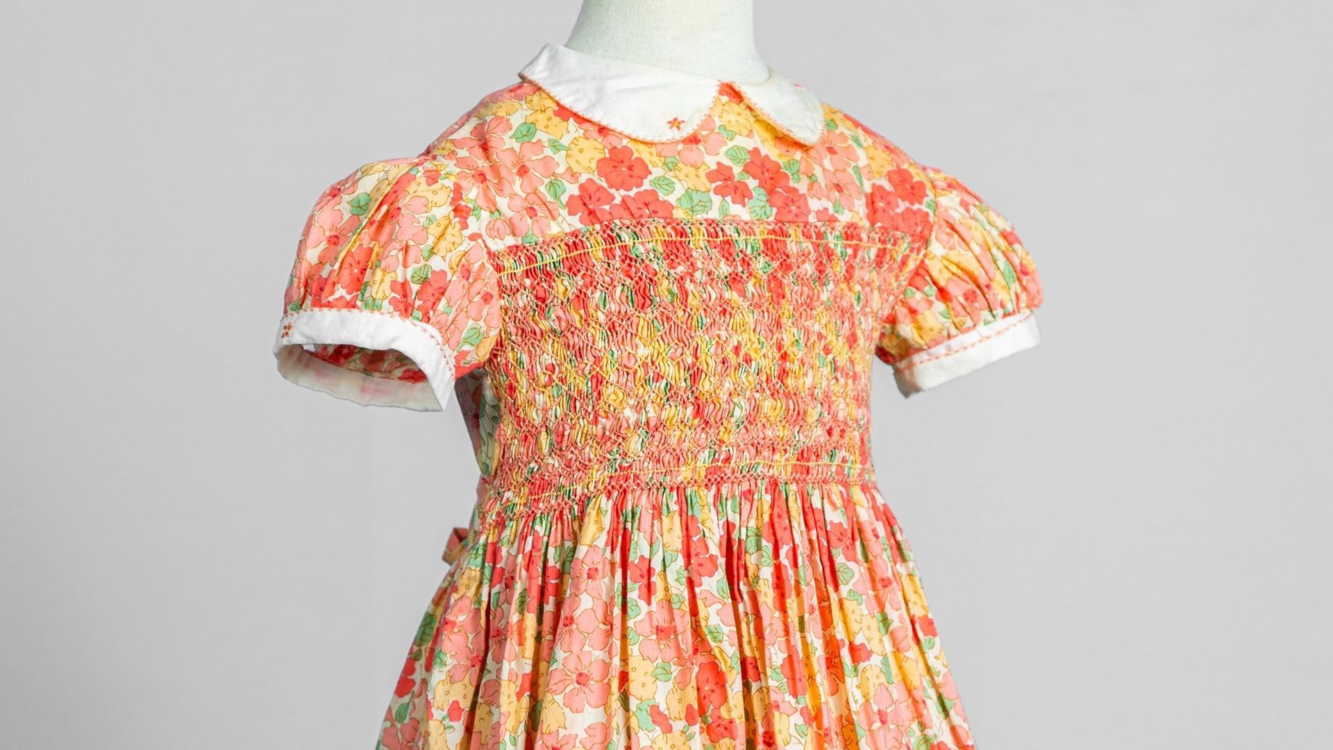 Datant des années 80, cette robe reprend tous les codes de la robe à smocks : col Claudine, manches bouffantes et buste orné de smocks.
