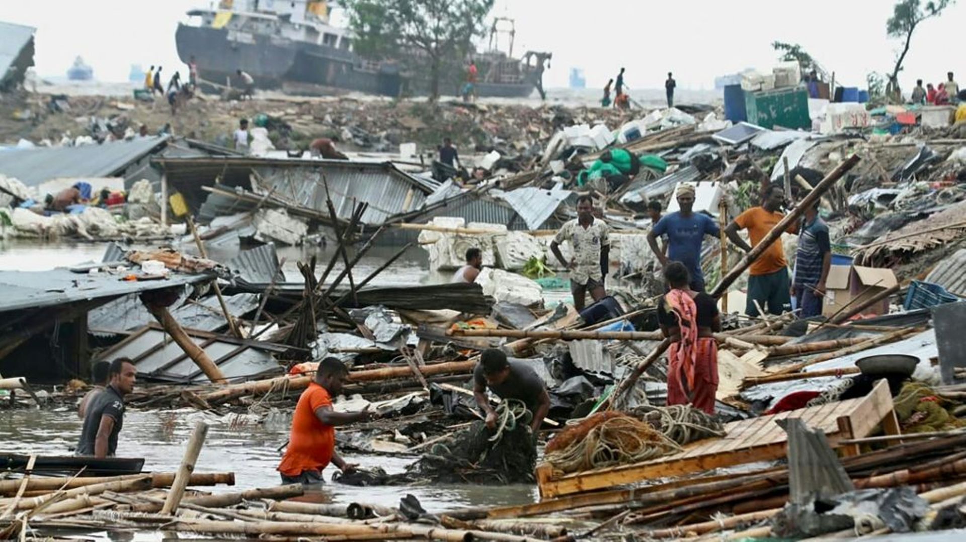 Des habitants recherchent des affaires dans les débris de leurs cabanes après le passage du cyclone Sitrang, le 25 octobre 2022 à Chittagong, au Bangladesh