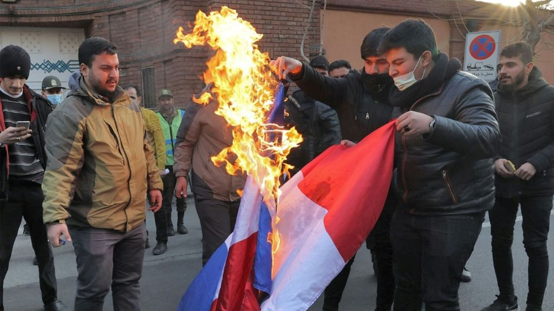 Des manifestants brûlent un drapeau français pendant un rassemblement devant l’ambassade de France à Téhéran contre les caricatures du guide suprême de la République islamique publiées dans le journal satirique français Charlie Hebdo, le 8 janvier 2023 pu