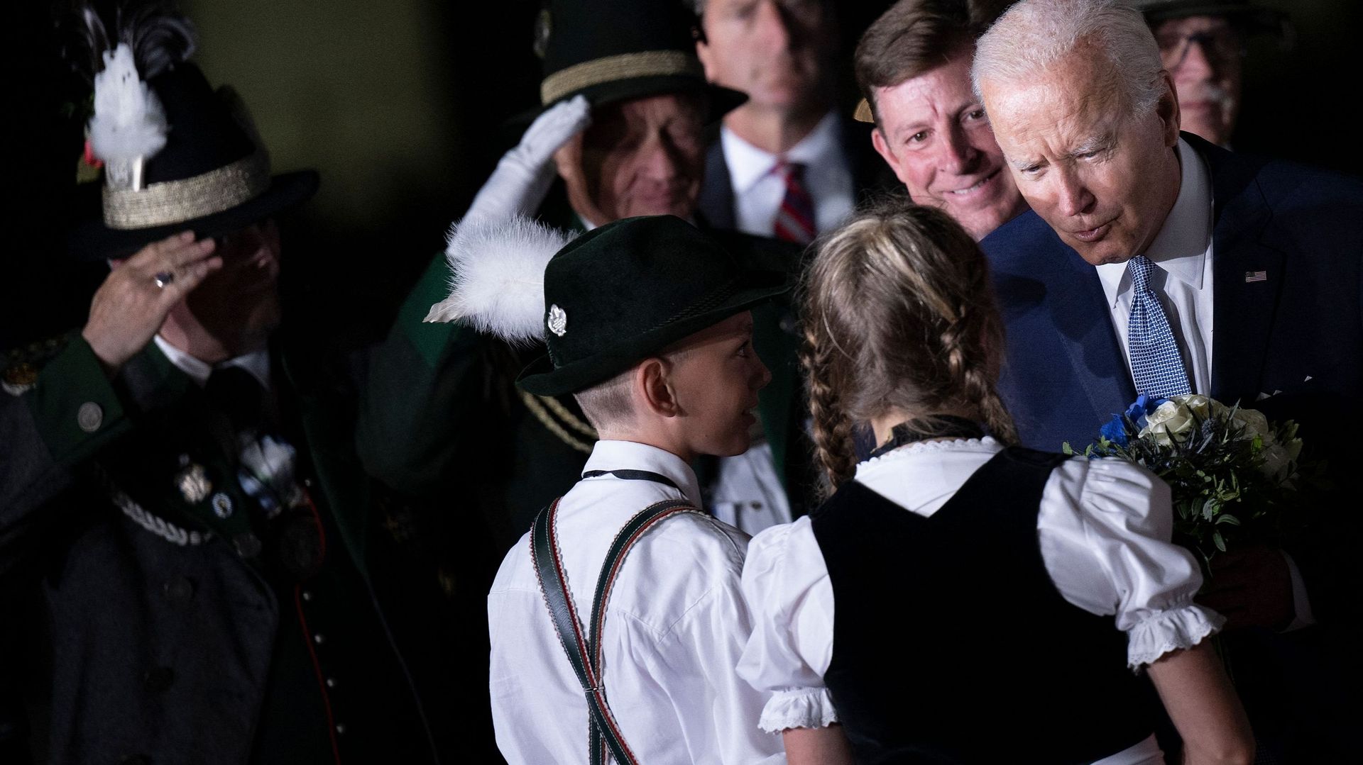 Le président américain Joe Biden (R) est accueilli par des enfants portant des vêtements traditionnels bavarois à son arrivée à l'aéroport Franz Josef Strauss de Munich, dans le sud de l'Allemagne, le 25 juin 2022, à la veille du sommet du G7.