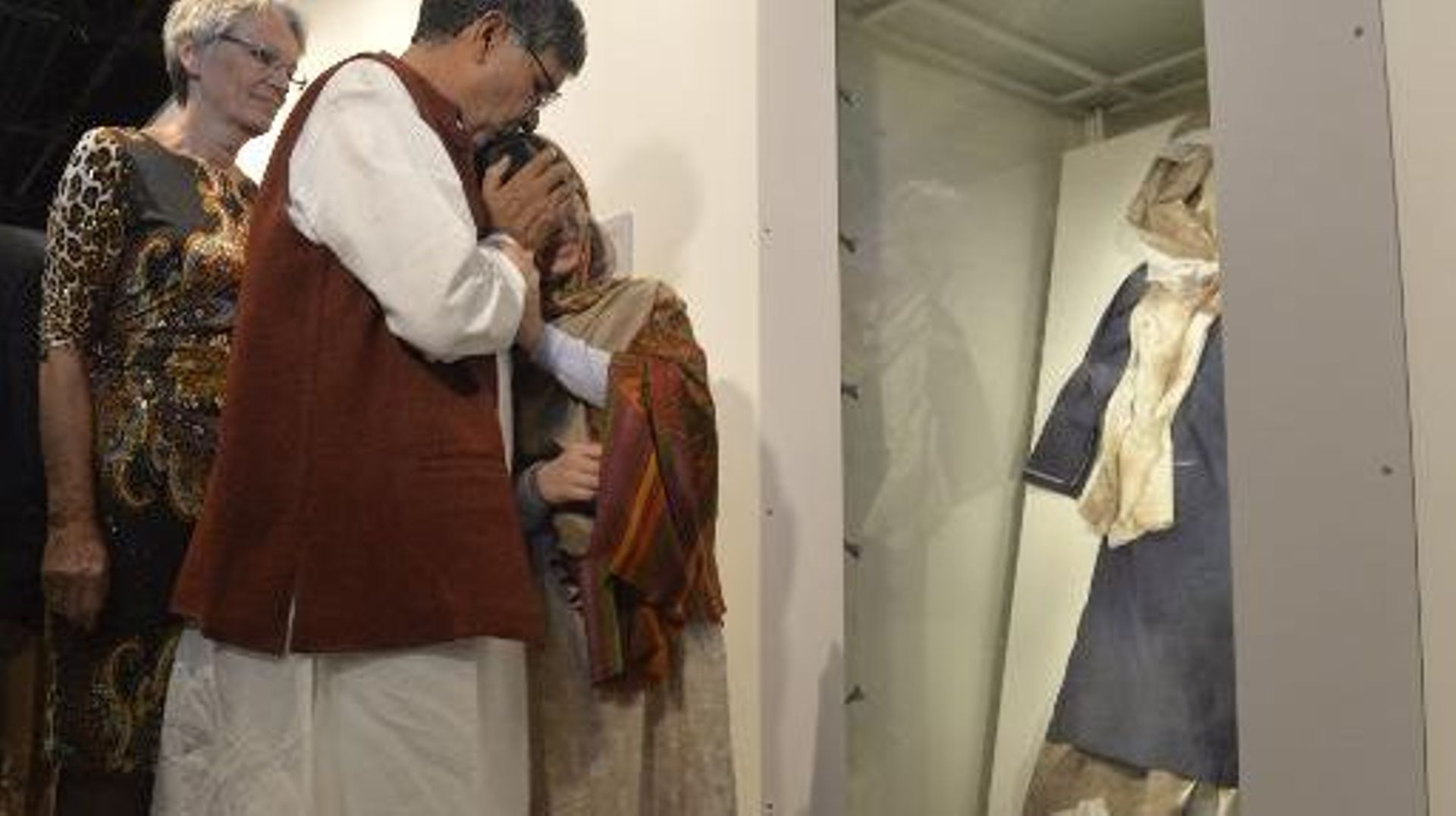 Kailash Satyarthi et Malala Yousafzai, prix Nobel de la paix, regardent l'uniforme de la jeune fille portant encore les stigmates de son agression, lors de l'inauguration de l'exposition au centre Nobal d'Oslo, le 11 décembre 2014