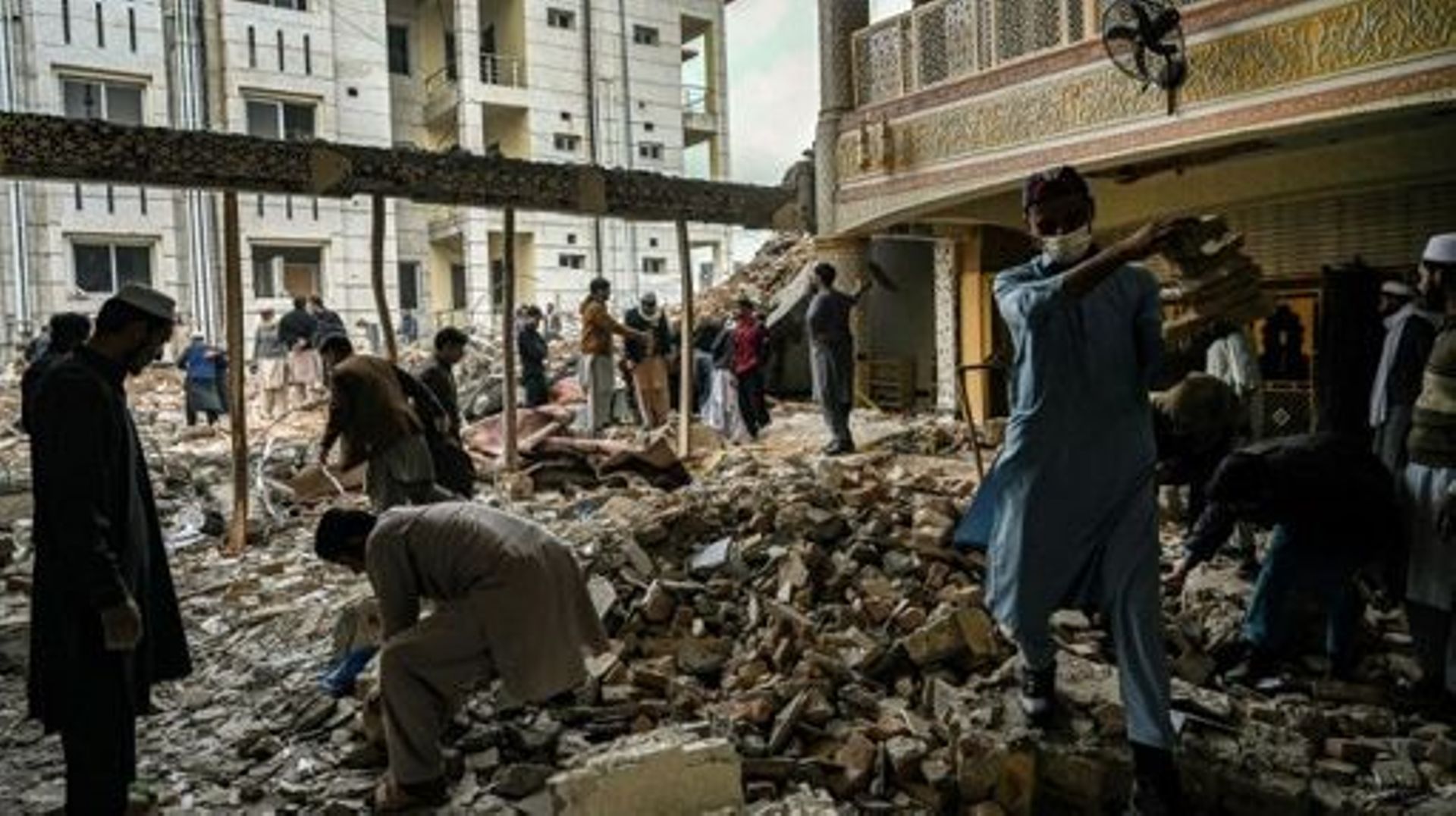 Plain-clothed policemen and labourers remove debris from a damaged mosque following January's 30 suicide blast inside the police headquarters in Peshawar on February 1, 2023.  A suicide blast at a mosque inside a Pakistan police headquarters was a targete