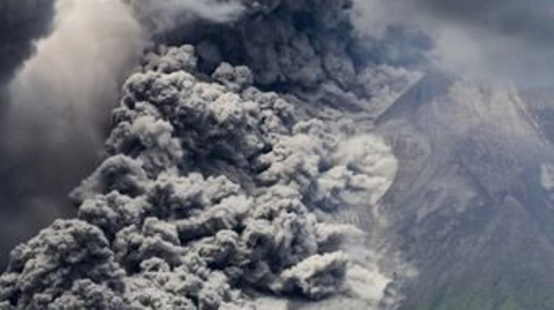 Une épaisse fumée s’élève lors d’une éruption du Mont Merapi, le volcan le plus actif d’Indonésie, vue depuis le village de Tunggularum à Sleman, le 11 mars 2023.
