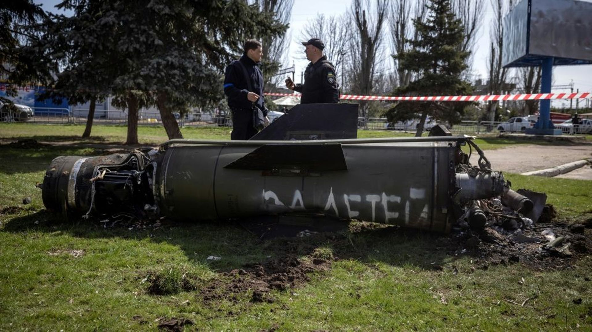 Des policiers ukrainiens devant les débris d’un missile sur lequel est écrit en russe "pour nos enfants" près de la gare de Kramatorsk, cible d’une attaque qui a fait 35 morts, le 8 avril 2022 dans la région du Donbass, dans l’est de l’Ukraine