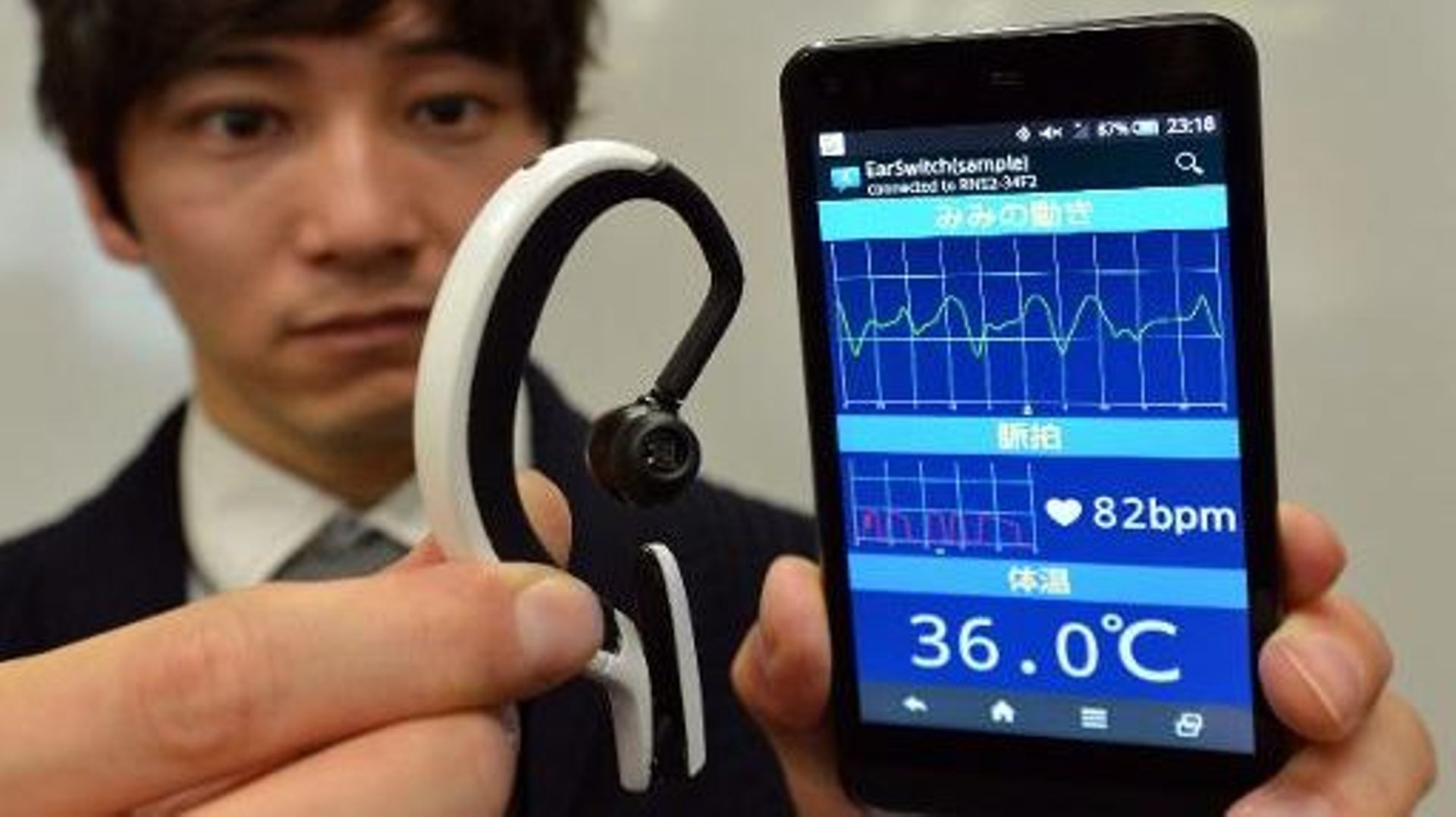 Un chercheur japonais présente un mini-ordinateur portable sur l'oreille que l'on pourrait contrôler d'un clin d’œil ou claquement de langue à Tokyo le 20 février 2014