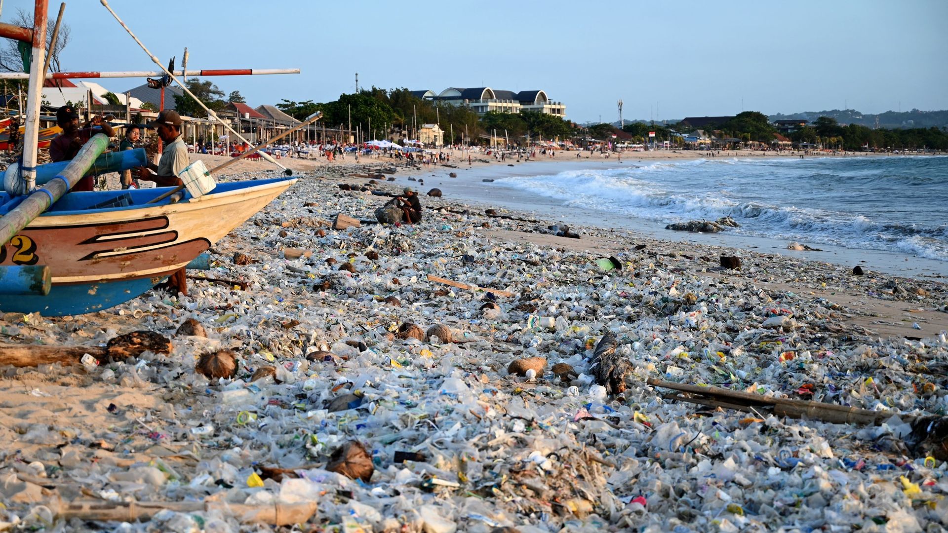 Un homme ramasse des objets recyclables pour les vendre au milieu de plastiques et d’autres débris échoués sur la plage de Kedonganan, près de Denpasar, sur l’île balnéaire de Bali, en Indonésie, le 19 mars 2024. SONNY TUMBELAKA / AFP