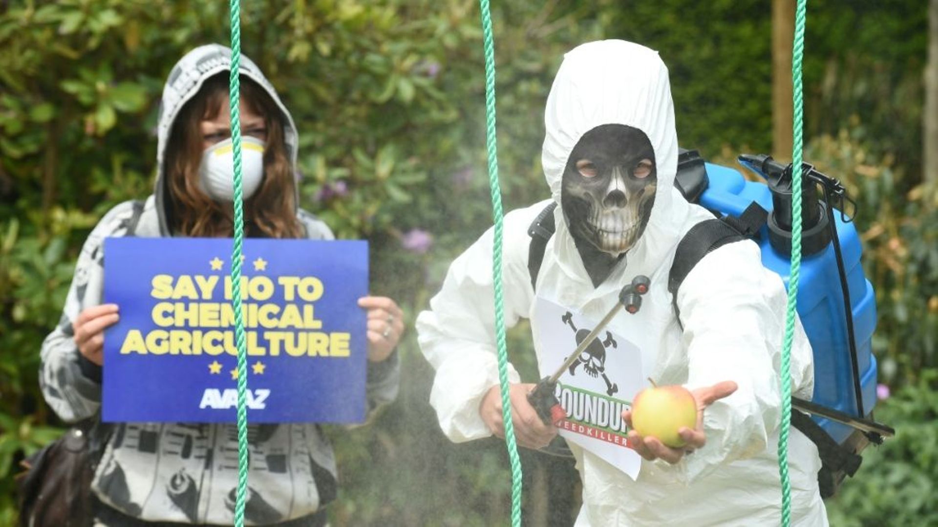 Des membres de l'ONG Avaaz déguisés en pulvérisateurs agricoles lors d'une manifestation contre le glyphosate à Bruxelles le 18 mai 2016
