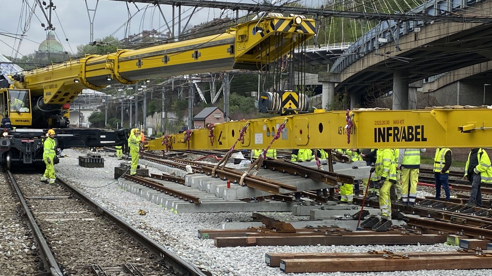 L’imposante grue ferroviaire pose un élément d’aiguillage