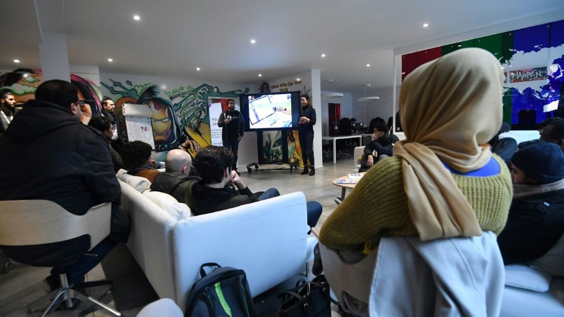 Les fondateurs de Molengeek Ibrahim Ouassari, un Belge du quartier de Molenbeek, et la française Julie Foulon accueillent des participants à une session de programmation au Centre MolenGeek à Molenbeek le 16 janvier 2018