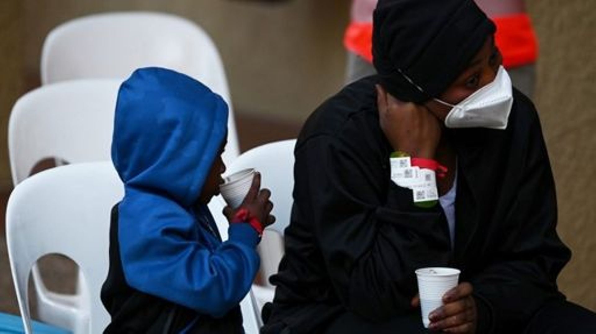 A woman and a child, rescued by the Ocean Viking rescue ship of European maritime-humanitarian organisation "SOS Mediterranee", drink as they arrive at the "Giens Cap Levant" holiday camp in Hyeres, southern France, where the migrants will be able to stay