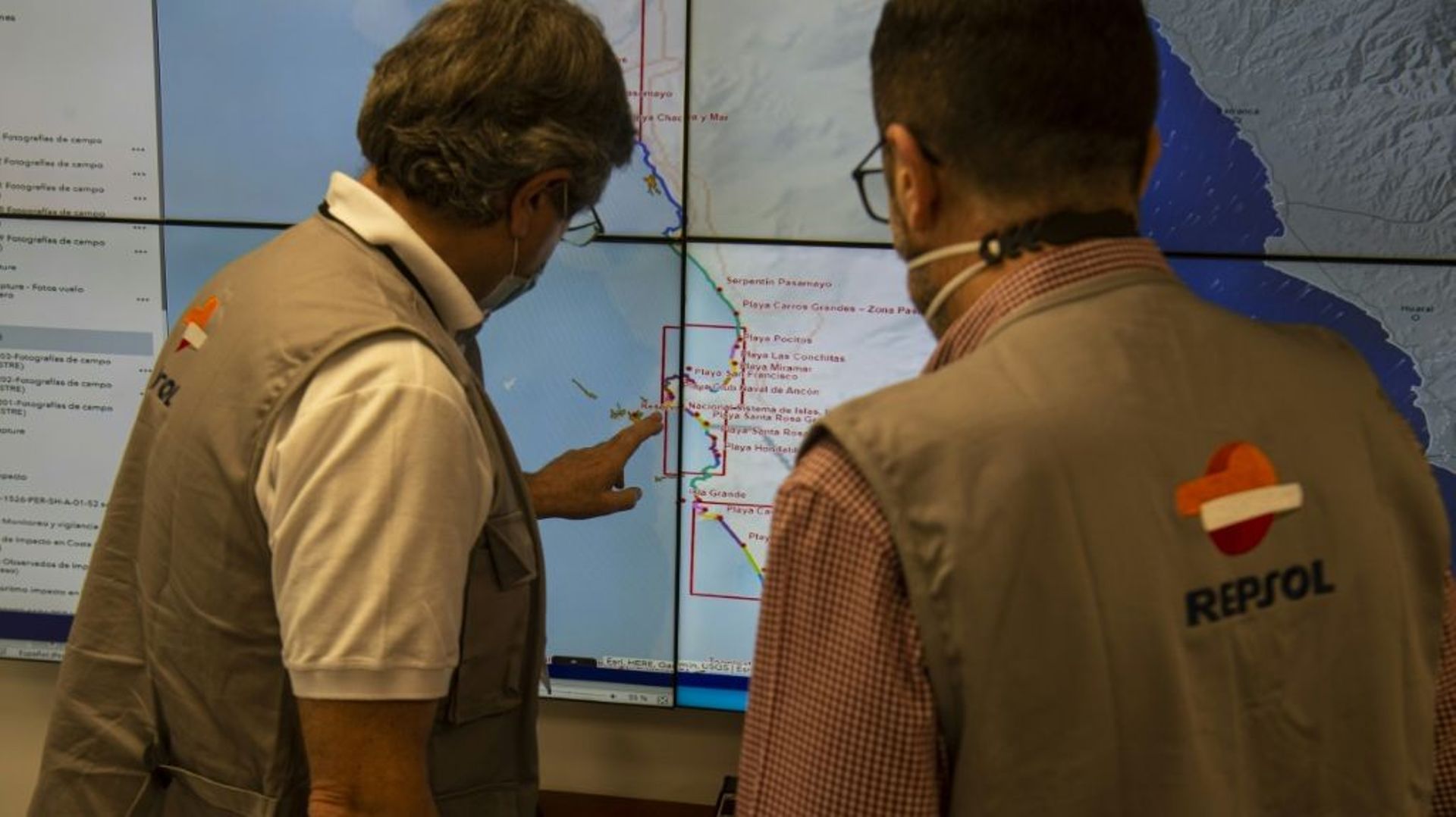 Des ouvriers de la compagnie pétrolière espagnole Repsol montrent sur une carte des zones de la côte du Pérou polluées par une marée noire de quelque 12.000 barils de pétrole, le 3 février 2022