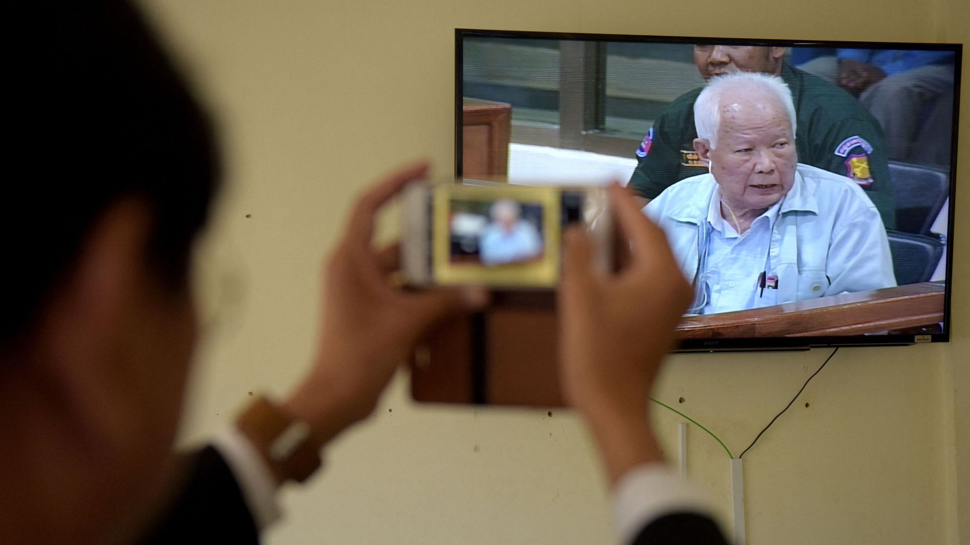 Photo d'archive prise le 23 juin 2017, une photo de l'ancien dirigeant khmer rouge Khieu Samphan alors que son image est diffusée sur un flux vidéo en direct pendant les déclarations finales de son procès aux ECCC à Phnom Penh.