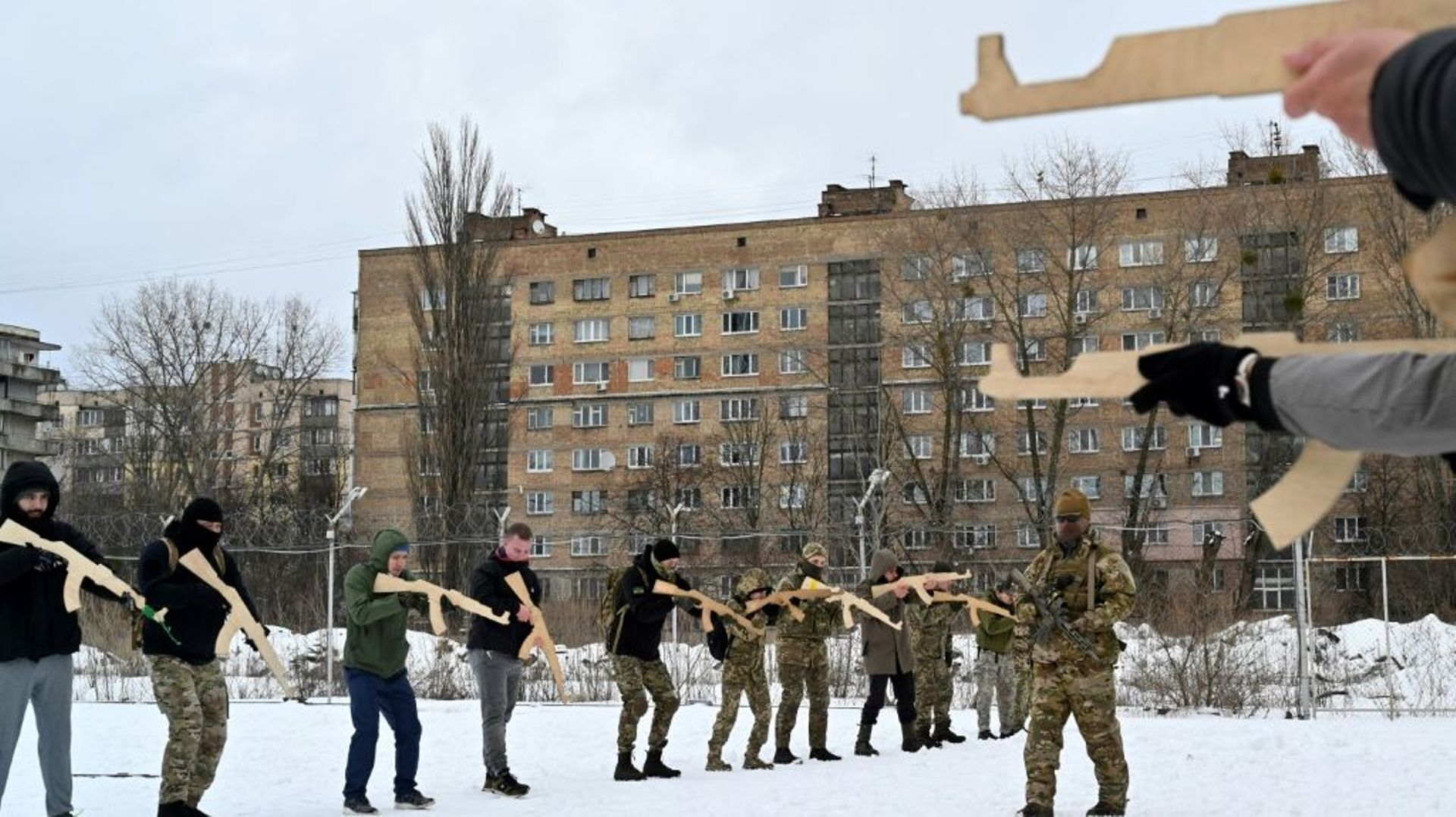 Un instructeur militaire apprend à des civils comment tenir des répliques de fusils Kalachnikov lors d'un entraînement à Kiev, le 30 janvier 2022 en Ukraine