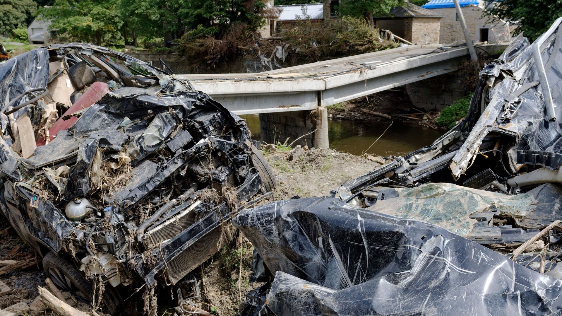Cette photo prise le 13 août 2021 montre des voitures détruites et un pont endommagé à Trooz, un mois après que la Vesdre est sortie de son lit, engloutissant la ville sous les eaux.