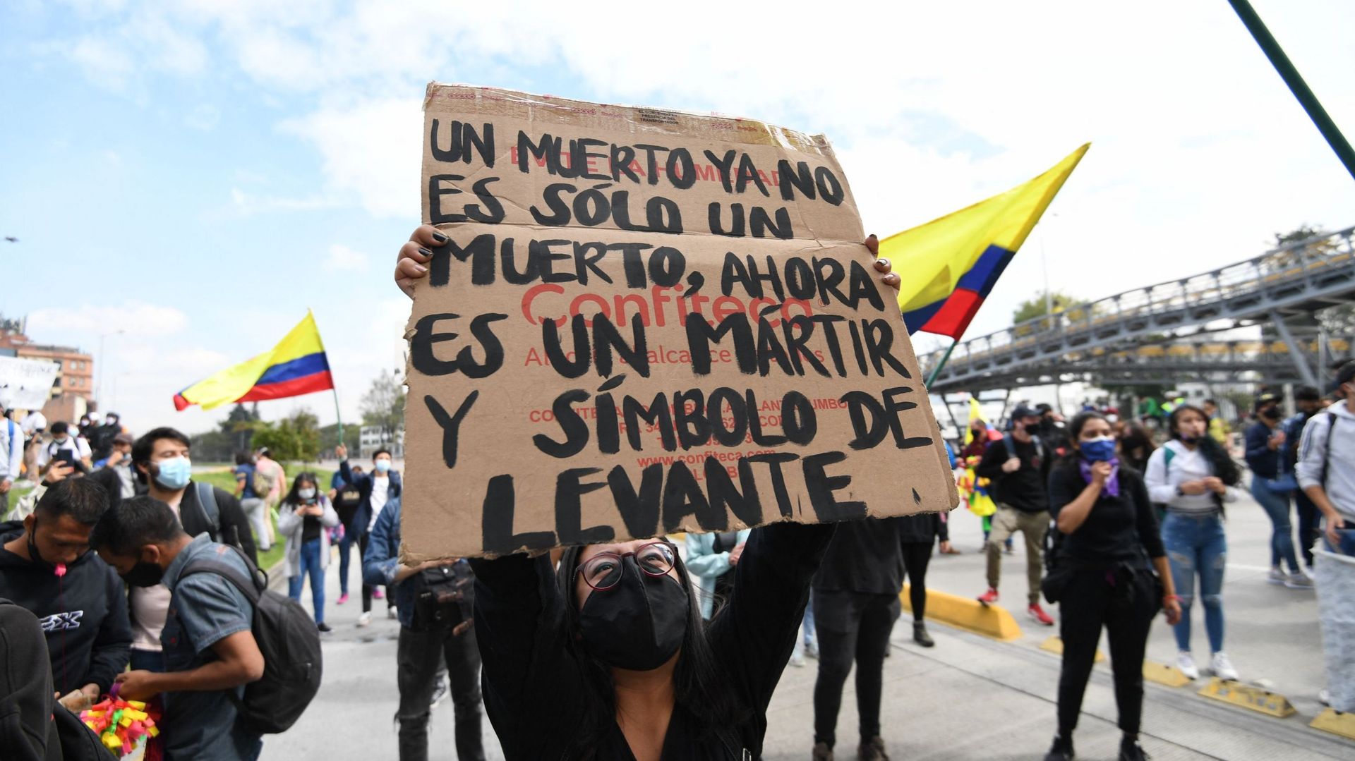Une femme brandit une pancarte affirmant "Un homme  mort est un martyr et un symbole" lors d'une manifestation à Bogota le 28 avril 2021