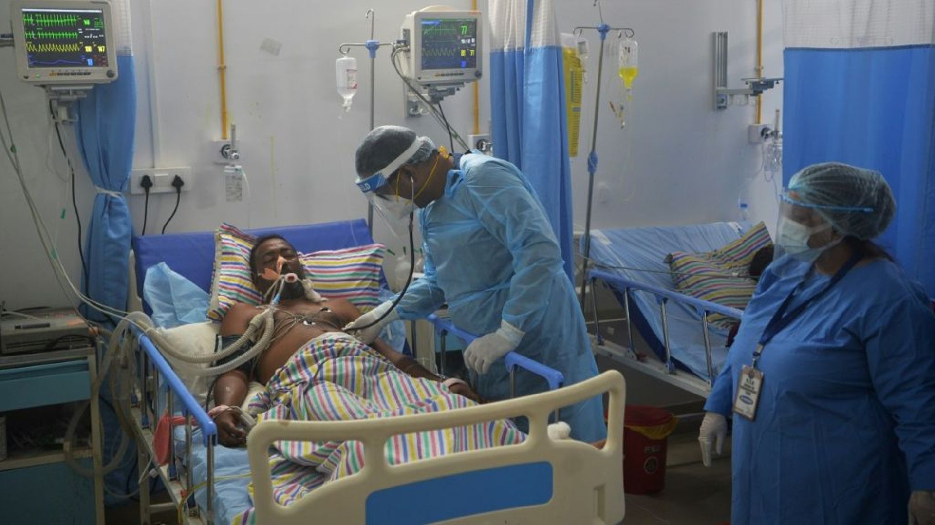 Un médecin examine un patient atteint du Covid-19 dans une unité de soins intensifs à l'hôpital Nightingale près de la localité de Siliguri en Inde le 1er juin 2021