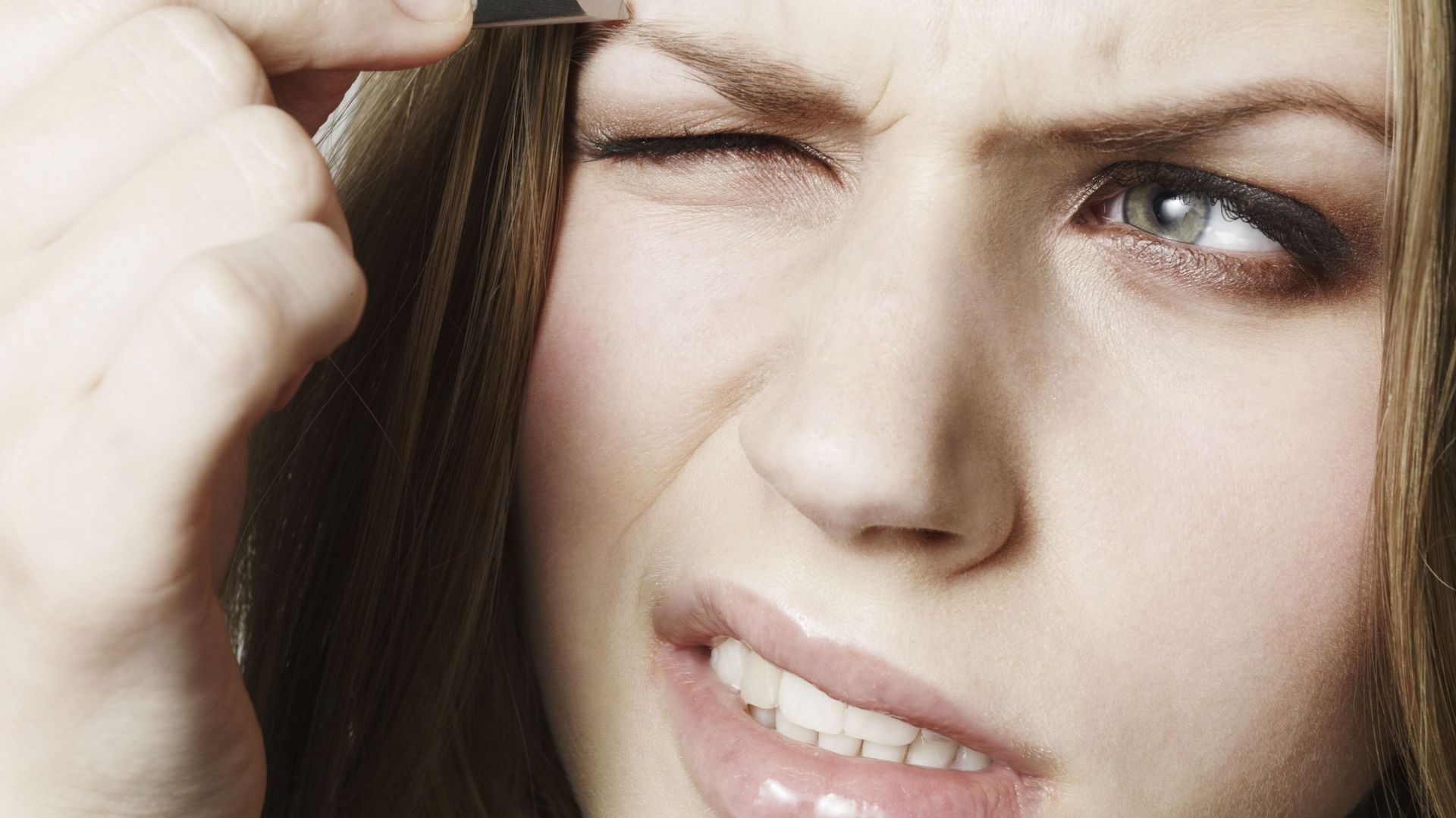 Woman Tweezing Her Eyebrows