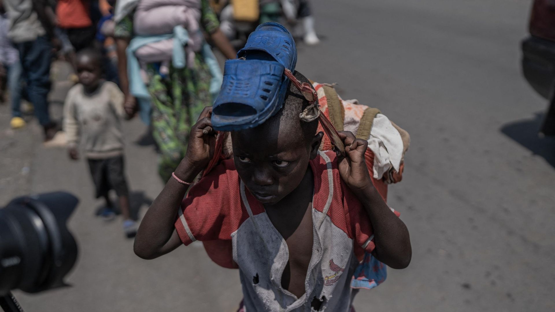 Un jeune garçon transporte certaines de ses affaires alors que les gens fuient le territoire de Masisi à la suite d'affrontements entre les rebelles du M23 et les forces gouvernementales, sur une route près de Sake, le 7 février 2024.