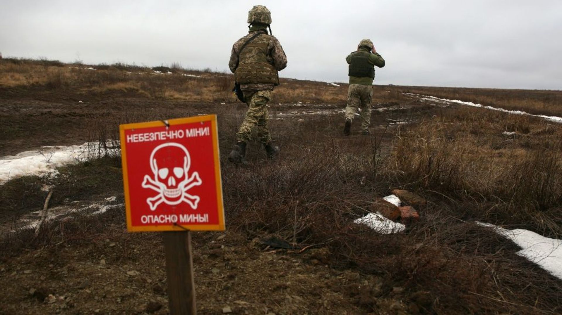 Des militaires ukrainiens patrouillent près d'un champ de mines sur la ligne de front, le 11 janvier 2021 à Luganske, dans la région de Donetsk