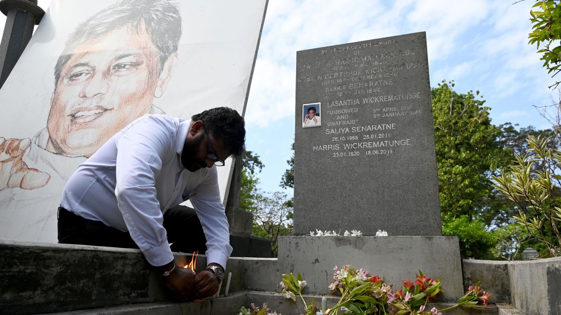 Un journaliste sri-lankais allume une bougie devant la tombe de l'éditeur assassiné Lasantha Wickrematunge à Colombo le 8 janvier 2020, à l'occasion du 11e anniversaire de sa mort.