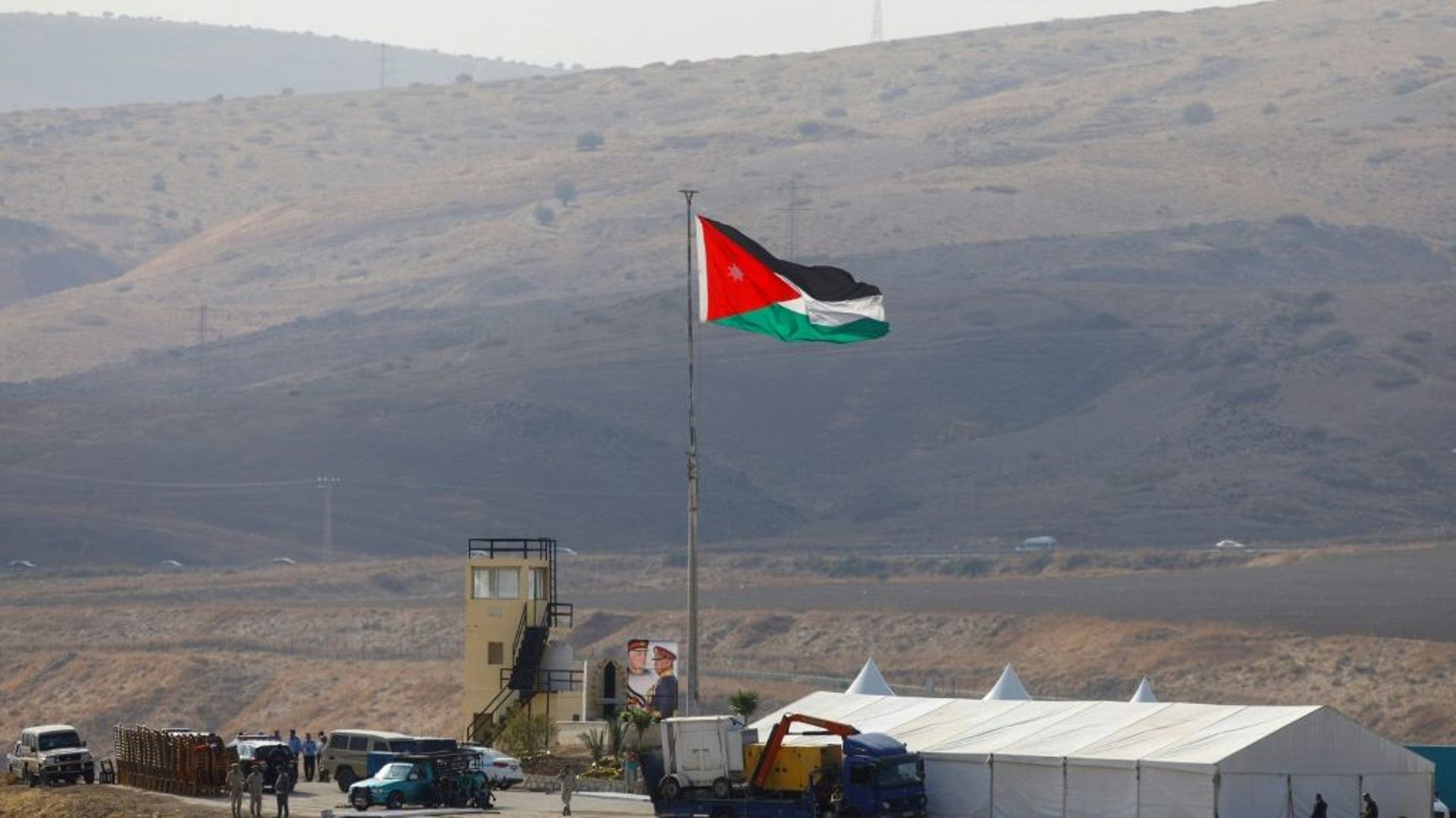 Image prise le 10 novembre 2019 côté israélien de la frontière jordanienne montrant des soldats jordaniens hissant le drapeau de leur pays dans le secteur de Naharayim/Baqoura qu'Amman vient de récupérer après avoir prêté ces terres agricoles à Israël pen