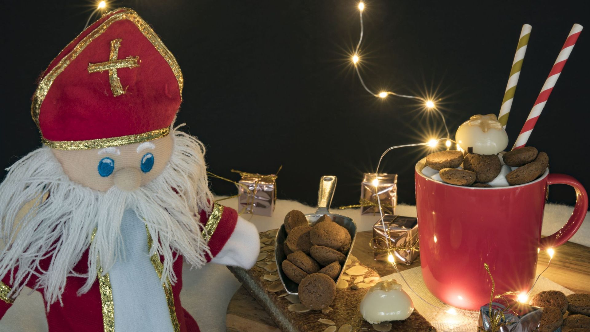 hot chocolate with marshmallows, kruidnoten, doll, for Dutch event Sinterklaas, against dark background