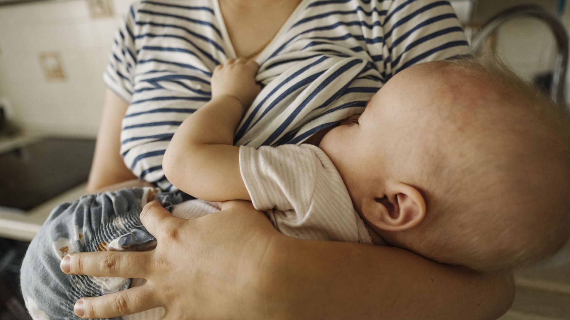 Mother&#39;s carrying toddler and breastfeeding at home