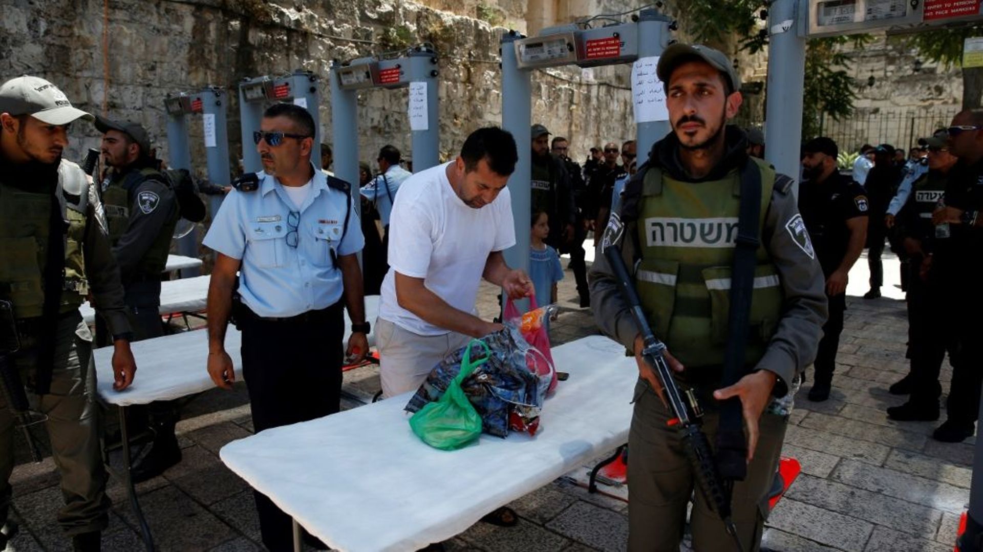 Un homme vide son sac après avoir traversé des portiques détecteurs de métaux, près de la Porte des Lions, l'une des principales entrées de la Vieille ville de Jérusalem, le 16 juillet 2017