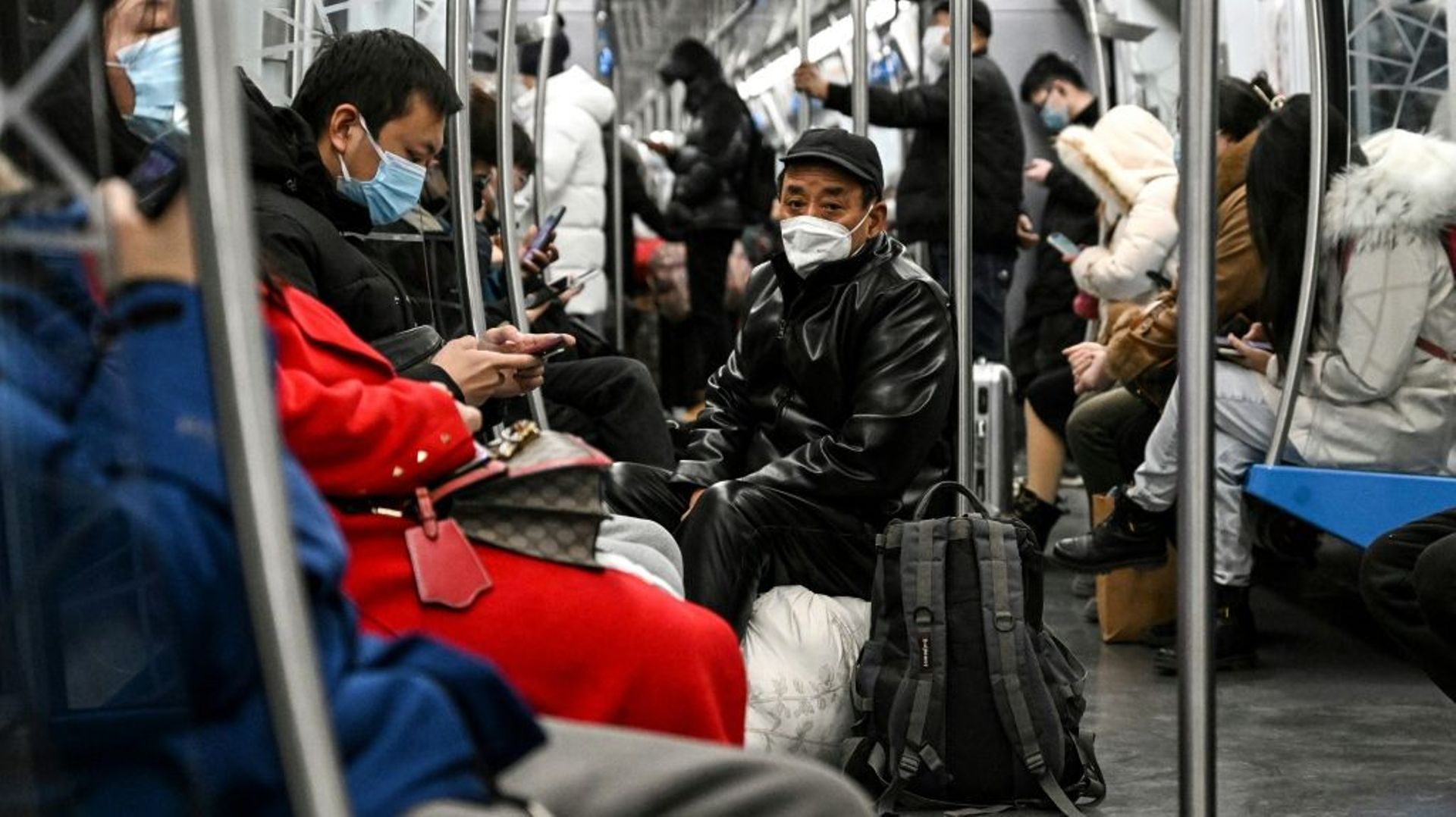 Des personnes portent des masques de protection dans une rame à Pékin le 19 décembre 2022