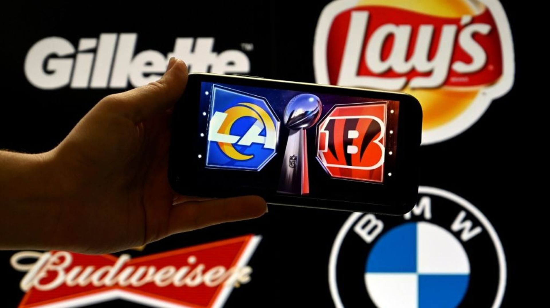 Les grandes marques Gillette, Lay's, Budweiser et BMW s'affichent en arrière-plan des logos des Cincinnati Bengals et des Los Angeles Rams à Washington, DC, le 9 février 2022   