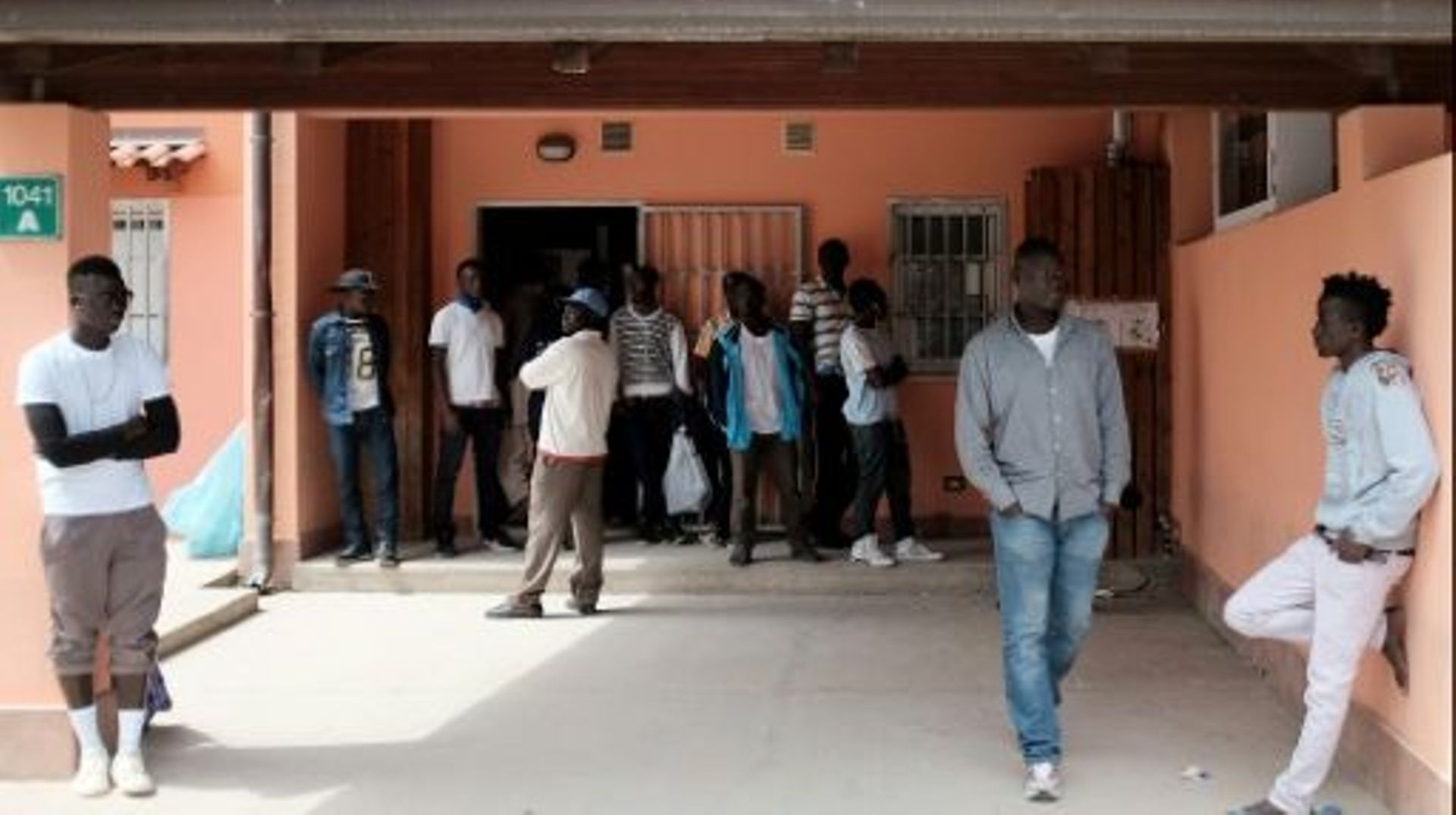 Des migrants attendent devant un centre d'accueil pour les demandeurs d'asile à Mineo, en Sicile, le 21 avril 2015