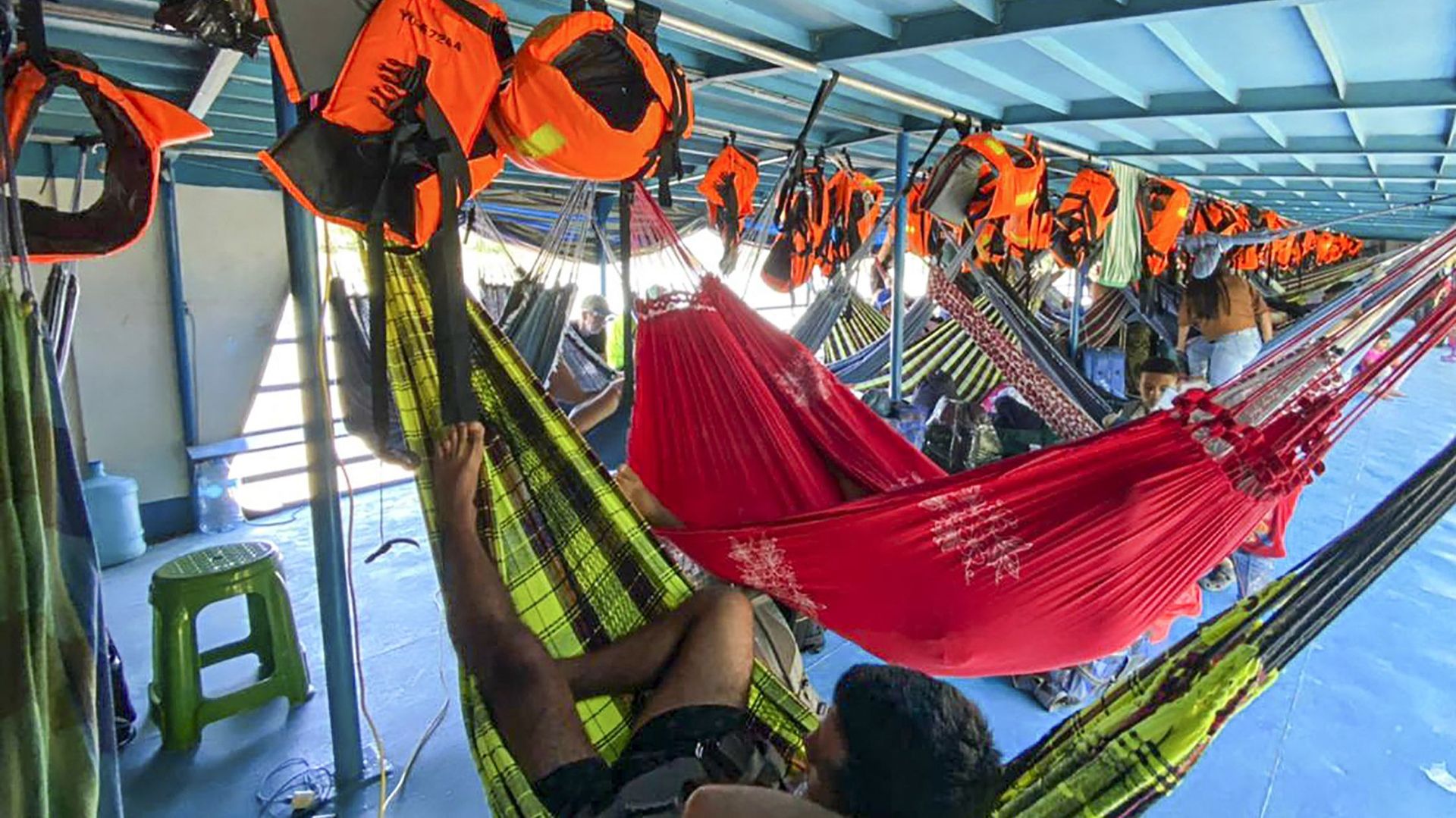 Des touristes étrangers et péruviens se reposent dans le bateau où ils ont été retenus dans la communauté de Cuninico à Loreto, au nord du Pérou, le 4 novembre 2022.