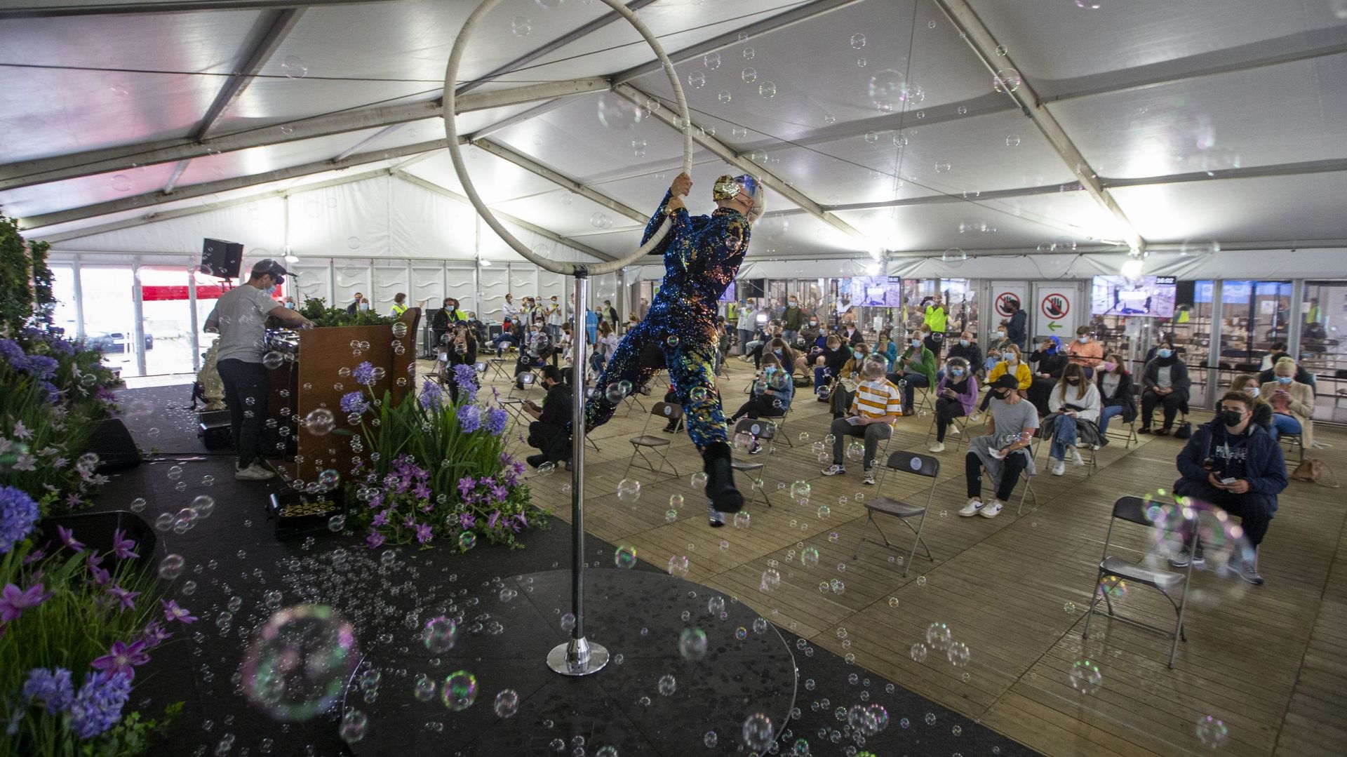Performances d'un acrobate et d'un DJ dans un centre de vaccination à Anvers, le 30 juin 