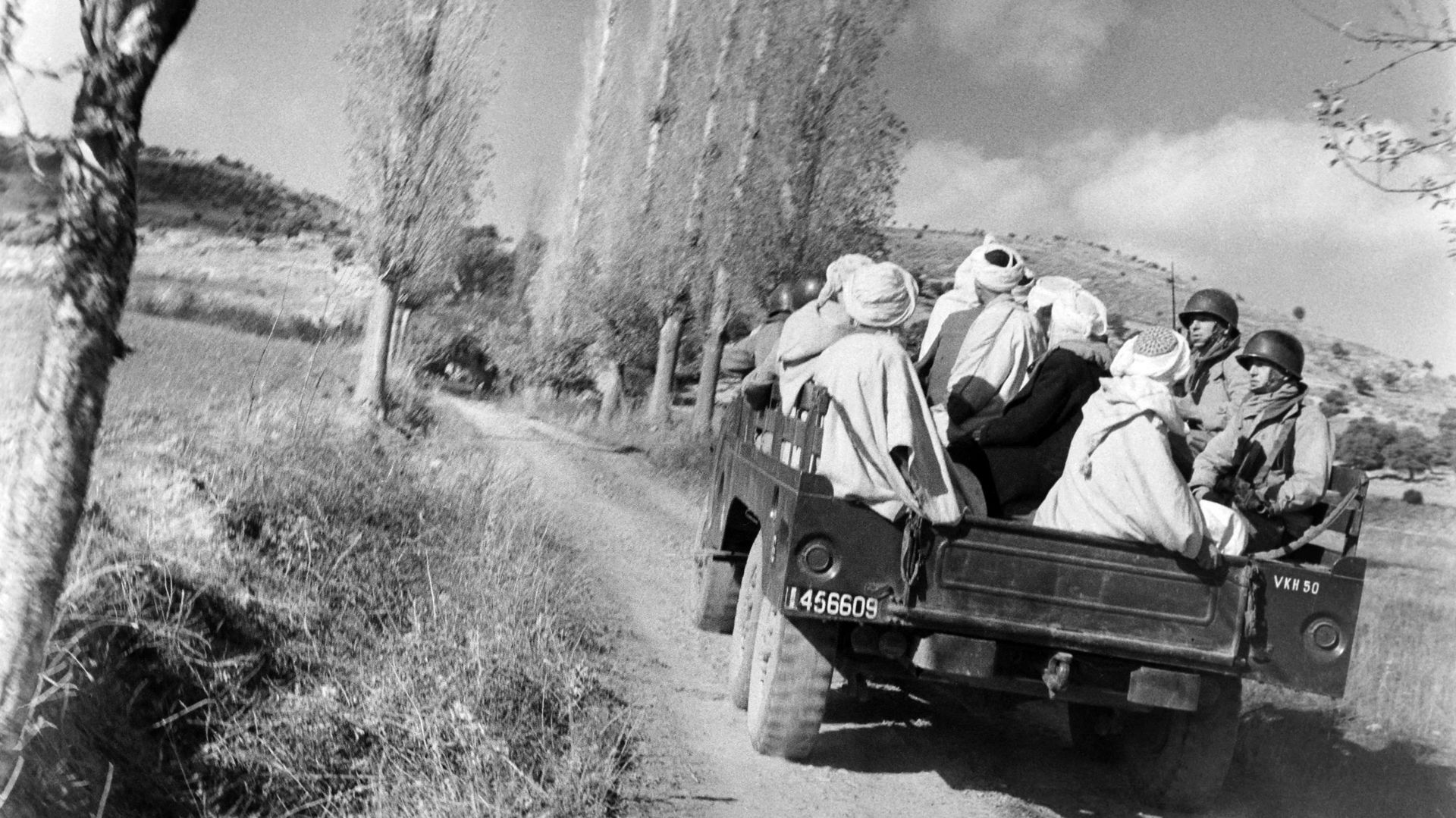 Des parachutistes de l'armée française escortent dix-huit combattants algériens capturés lors de violents combats dans le massif des Aurès entre Arris et Batna, le 30 novembre 1954 vers le quartier général du général Gilles, commandant de la 25e division 