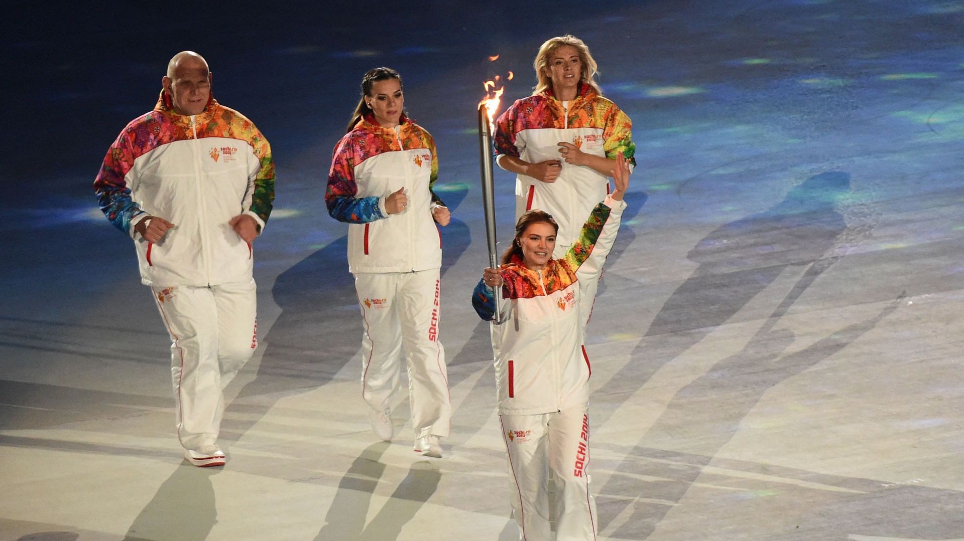 La gymnaste russe et médaillée olympique Alina Kabaeva tient la torche olympique lors de la cérémonie d'ouverture des Jeux olympiques d'hiver de Sotchi au stade olympique Fisht, le 7 février 2014 à Sotchi. 